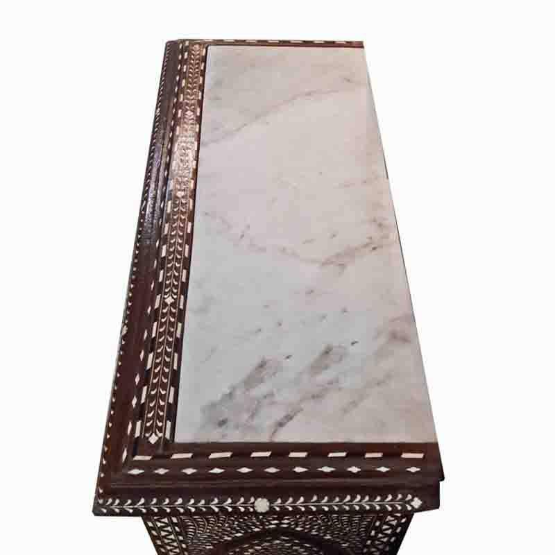 A chest of drawers from India, in bone-inlaid teak wood, with a white marble top. Traditional inlay pattern. Two small drawers, three large drawers. Discreet brass ring pulls and turned short legs.