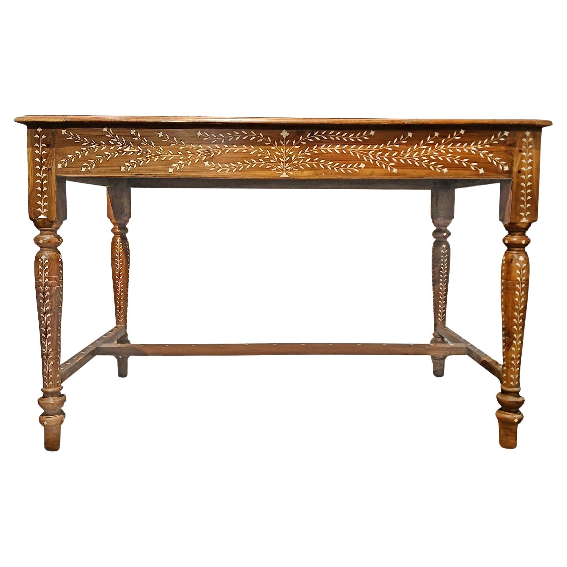 A beautiful writing desk, handcrafted in India out of aged teak wood and responsibly sourced animal bone inlay. Late 20th Century (1990-1995).  Narrow apron, bottom stretchers in H pattern, two vertical and one horizontal. 

Inlay is an ancient