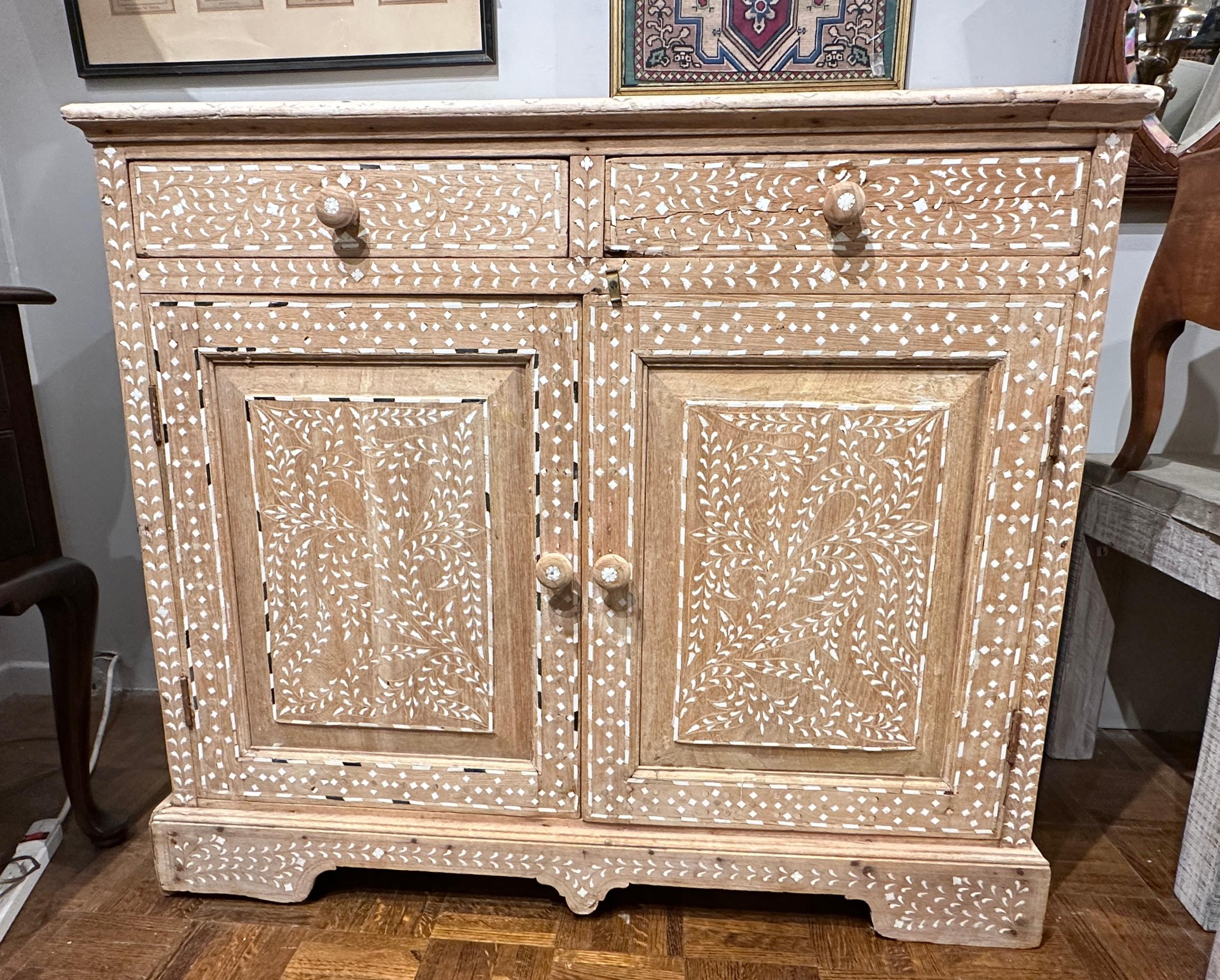 Circa late 19th Century, Moroccan bone inlay cabinet with two drawers and storage cabinet below.  Il est très décoratif, avec des incrustations florales en os,  Le bois de teck blanchi donne un aspect très rustique.