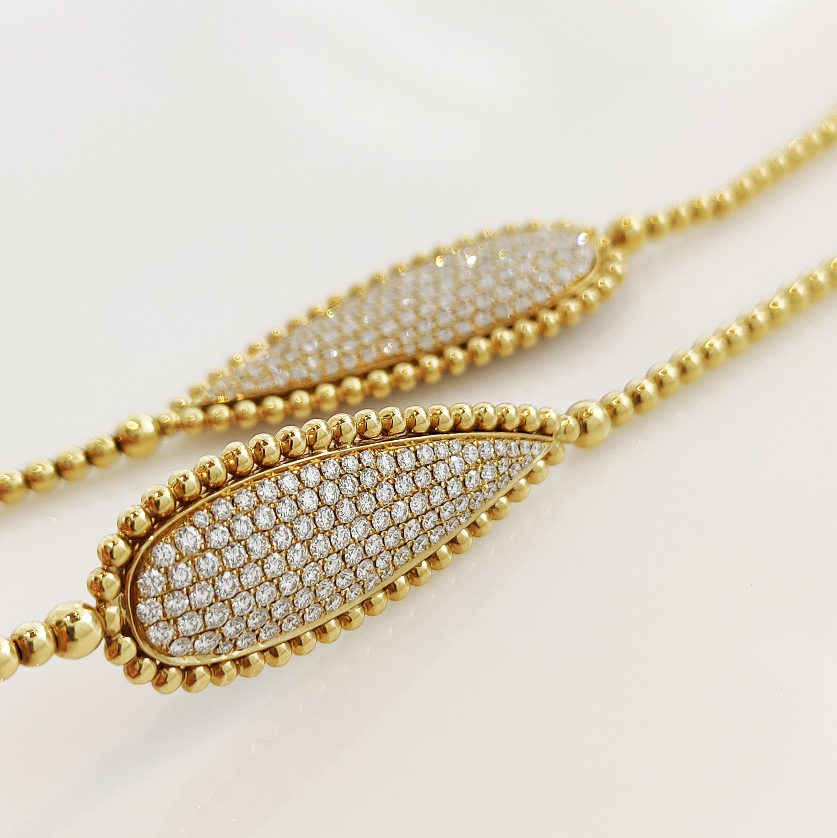 18 karat yellow gold necklace featuring 2 drop motifs bordered by gold beads with finesse. These two motifs are set on both sides with diamonds: 428 diamonds, a total weight of 7.57 carat in a G-H colour and VS clarity, the total weight of the