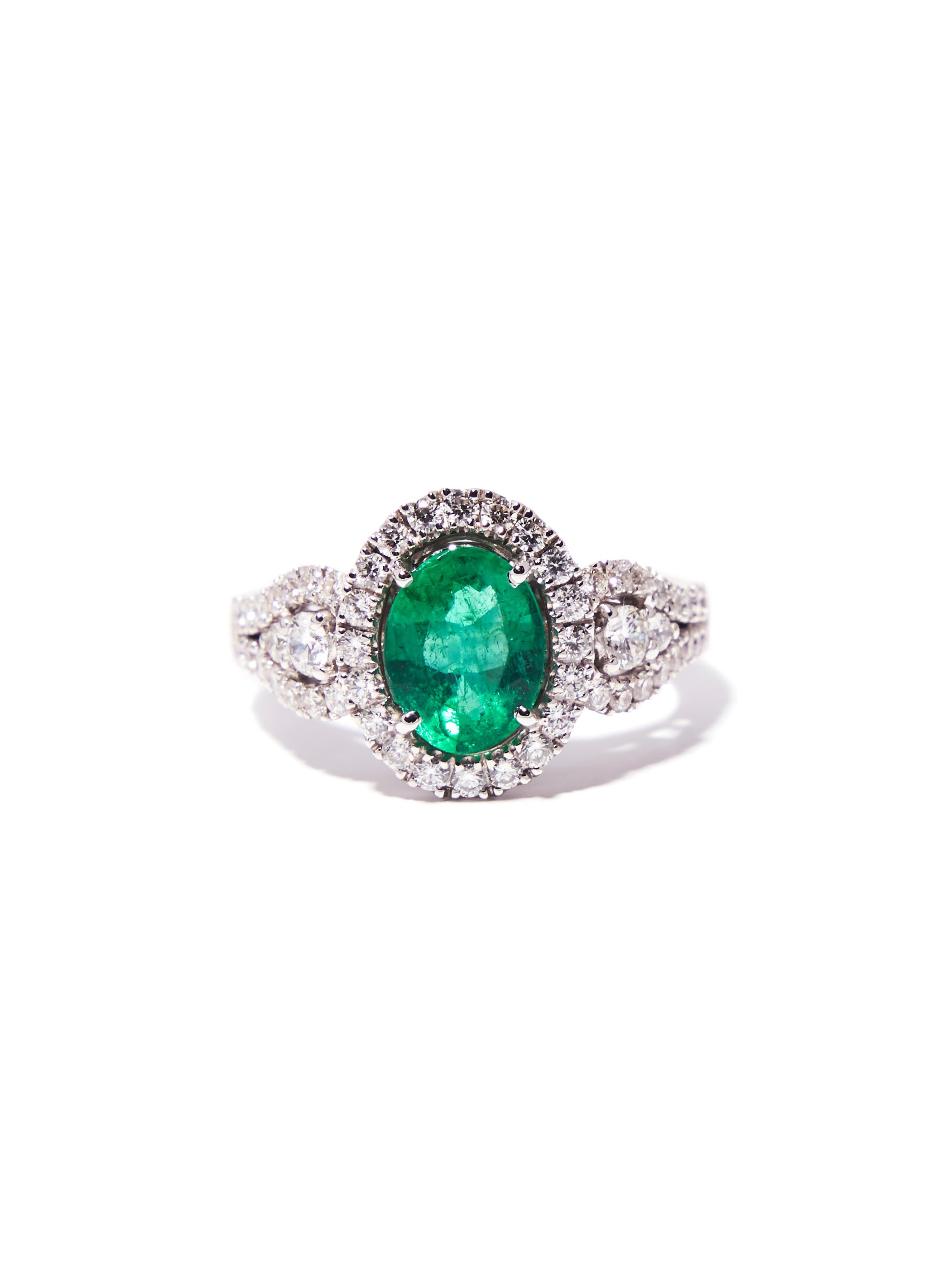 This 1.50 carat oval emerald set in 18 karat white gold can be a magnificent engagement ring or an eye-catching cocktail ring. The lavish green center stone is adorned with brilliant cut diamonds (total 0.95ct G / VS ) in a halo and as a cascade