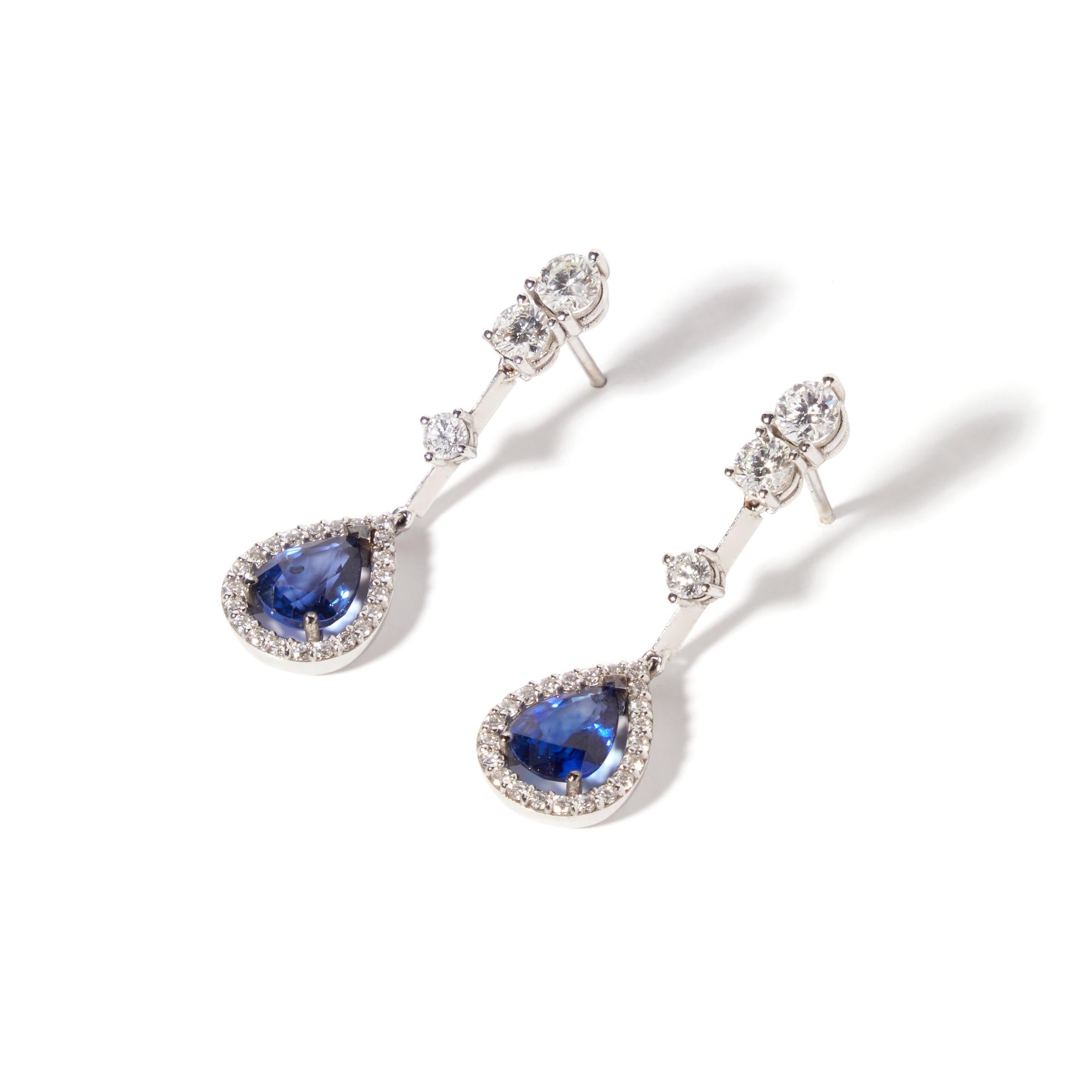 These earrings blend contemporary taste with an Art-Deco feeling through a unique gold frame that highlights its elegant form. They make the intense blue pear-cut sapphires stand out. These earrings are made in 18kt white gold, and are set with a