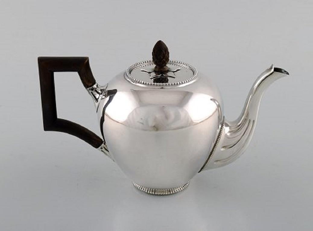 Bonebakker & Zoon, Amsterdam. Silver teapot with handle and wooden knob. Beaded border in top and bottom. Knob shaped like a spruce cone.
Measures: 20 x 12.5 cm.
Stamped.
In very good condition.

    