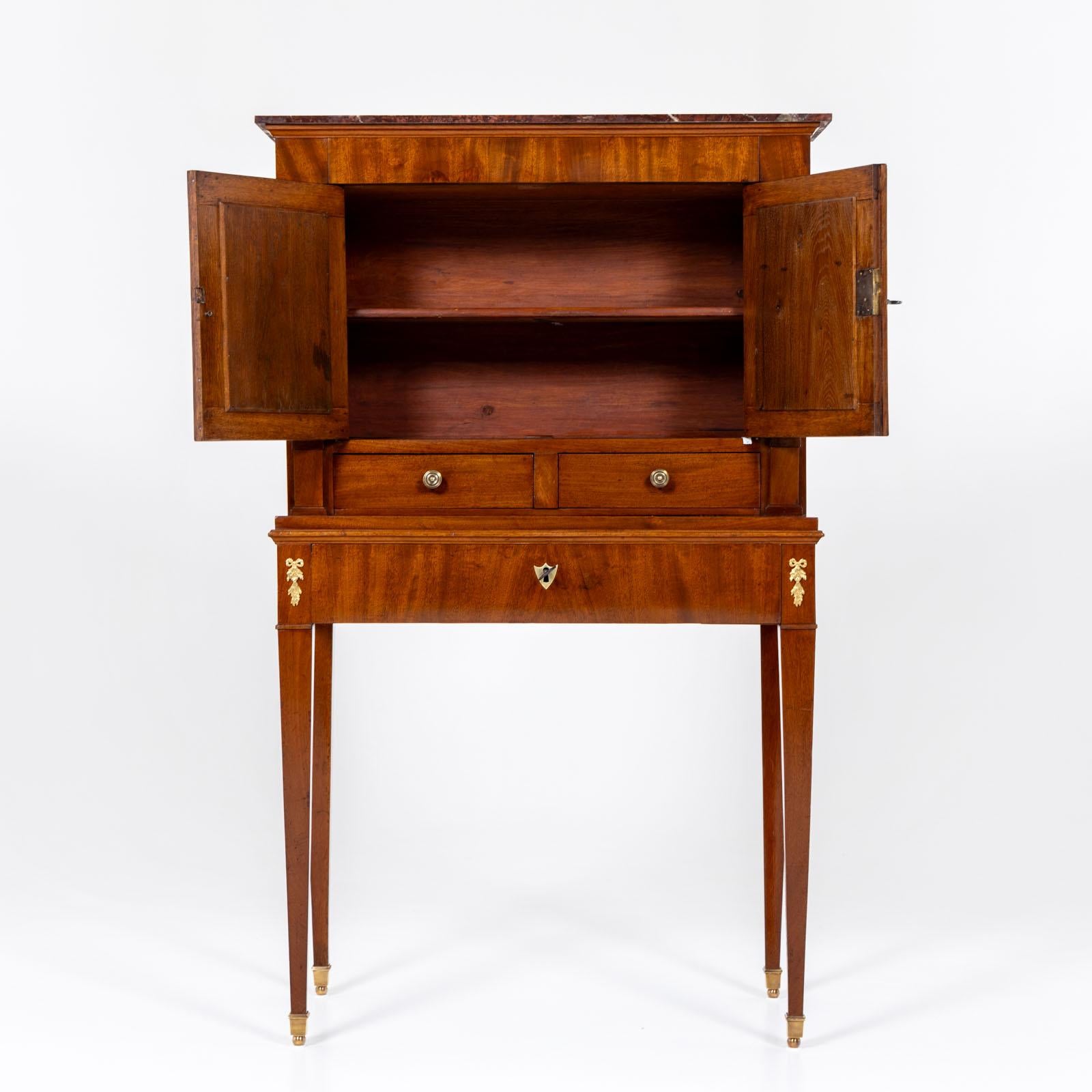 Two-door Bonheur du Jour ladies' secretaire standing on tall, tapered legs with brass sabots, featuring a leather-covered writing surface in the lower drawer and compartments for inkwells and penholders. The writing surface slides open to reveal