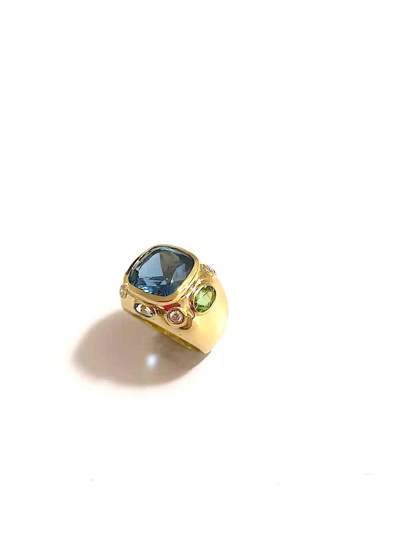 The BONHEUR Ring: 18kt Yellow Gold Domed Ring with faceted Dark Blue Topaz  Cushion cut center stone and faceted ovalPeridot and Pale Blue Topaz  and round Diamonds. 

This ring is available in in any color stone combination.

This ring may be
