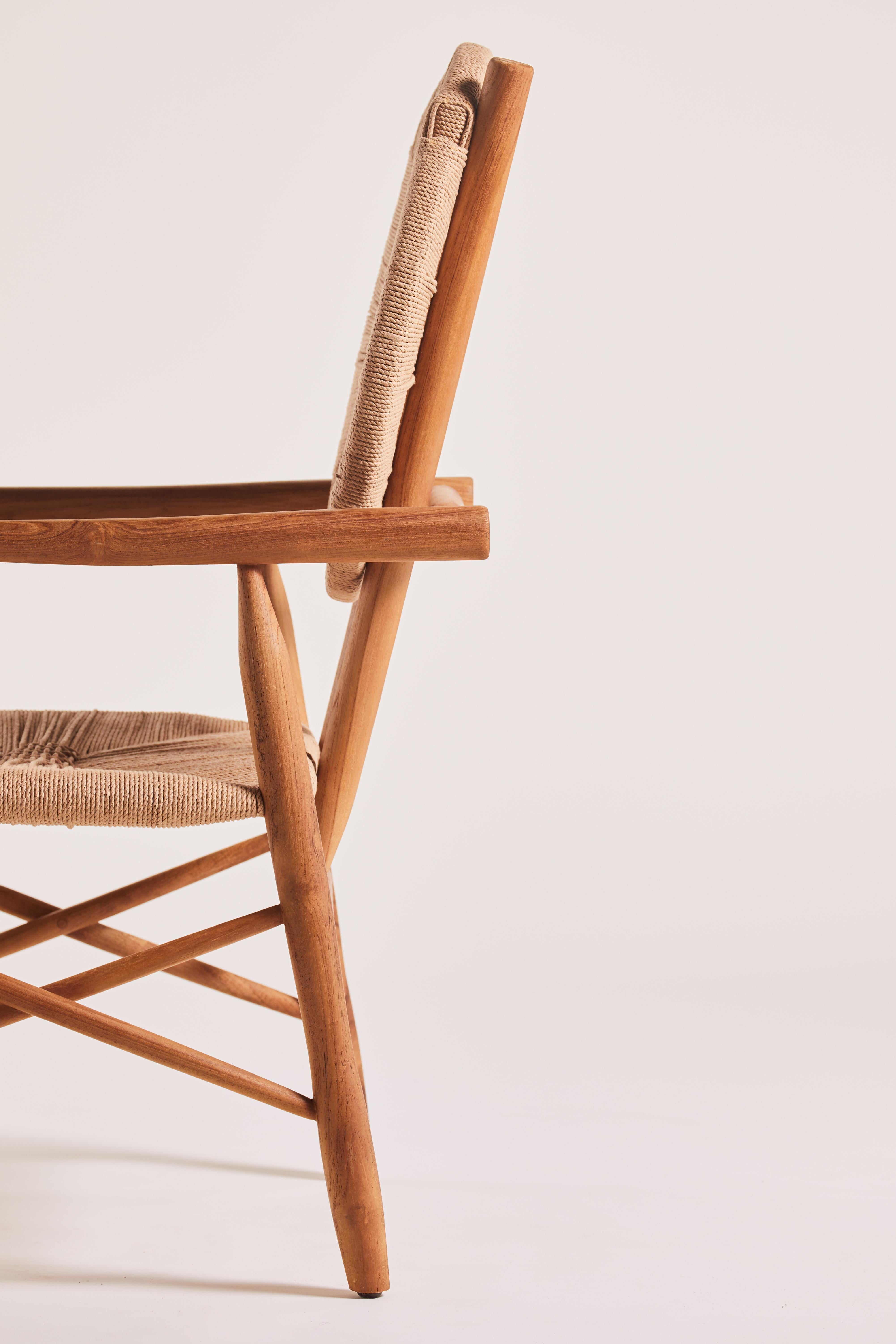 The Boni Dining Chair is constructed from a rich, elongated teak wood frame and a braided back and seat made from recycled paper rope. It blends modern aesthetics with an organic, textured finish, bridging contemporary design with nature-inspired