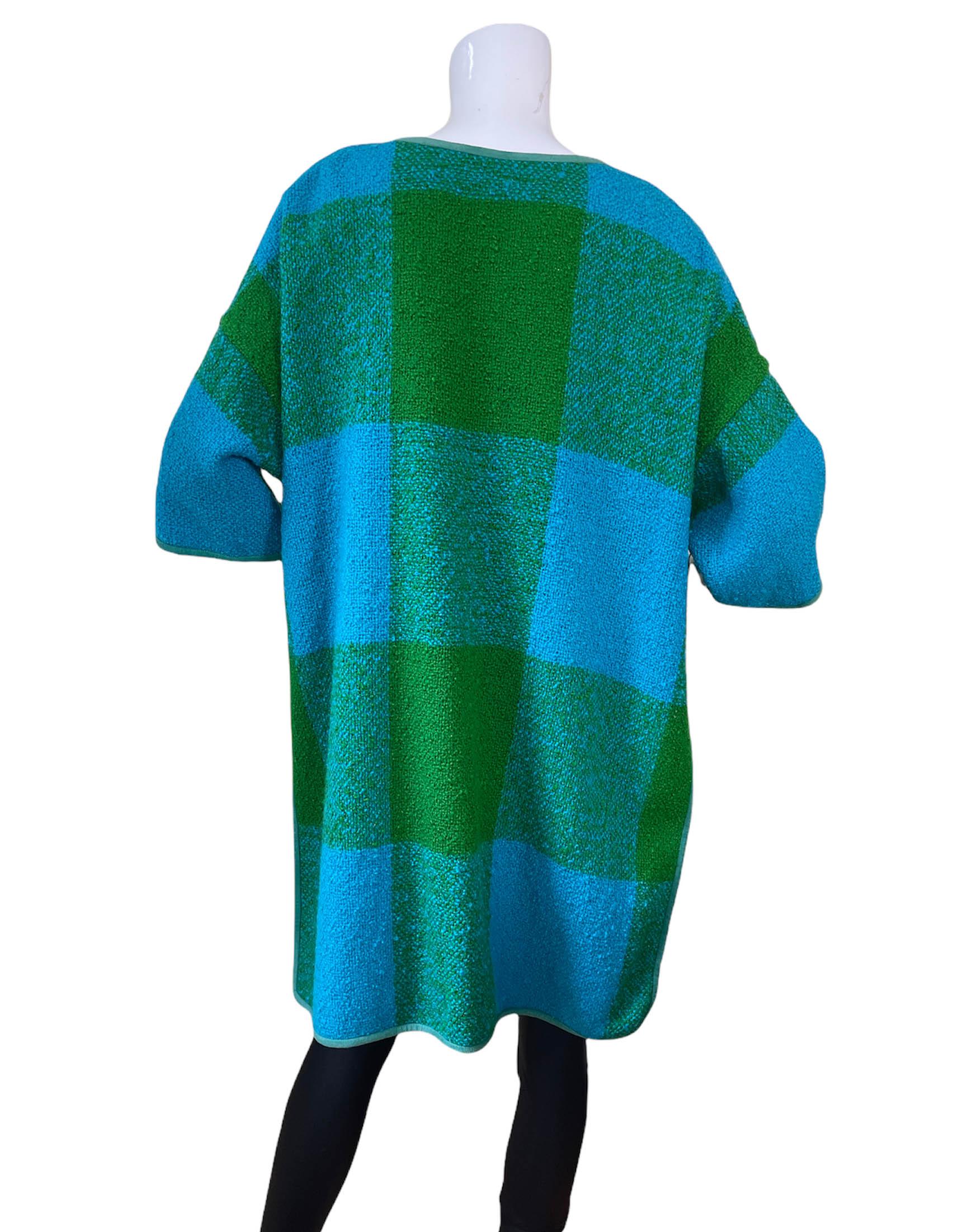 Bonnie Cashin 1960s Blue/Green Plaid Boucle Blanket Coat.  Features drop shoulders and fully slit sides from underarm to hem.

Year of Production: 1960s
Color: Blue and green
Materials: Wool with suede trim- missing composition tag
Lining: