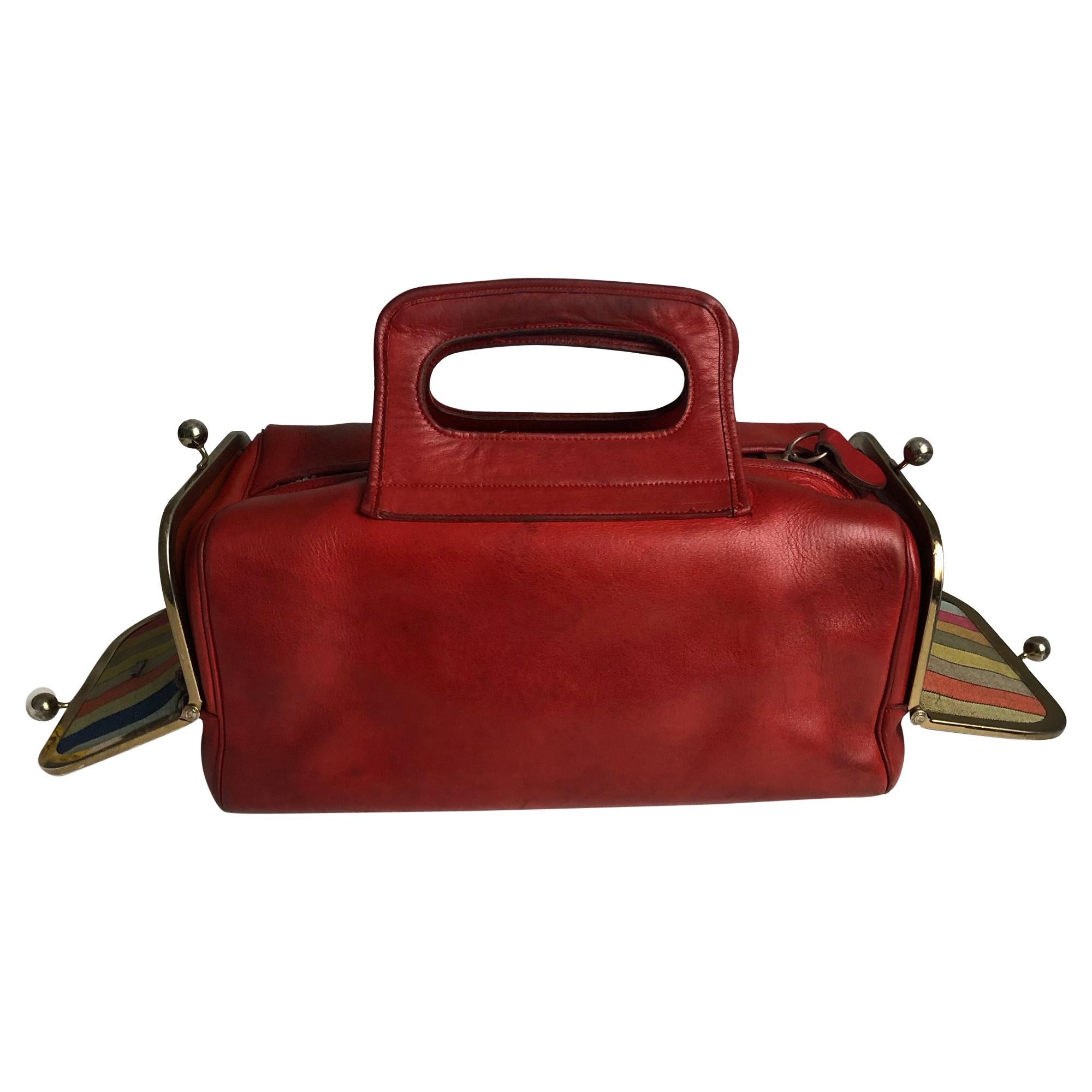 Preowned, vintage Bonnie Cashin for Coach Leatherware 'Double Header' tote bag with kiss locks, likely made in the 60s.  Made from red leather, there's a kiss lock pocket on each side and a zippered main compartment, all lined in Cashin's signature