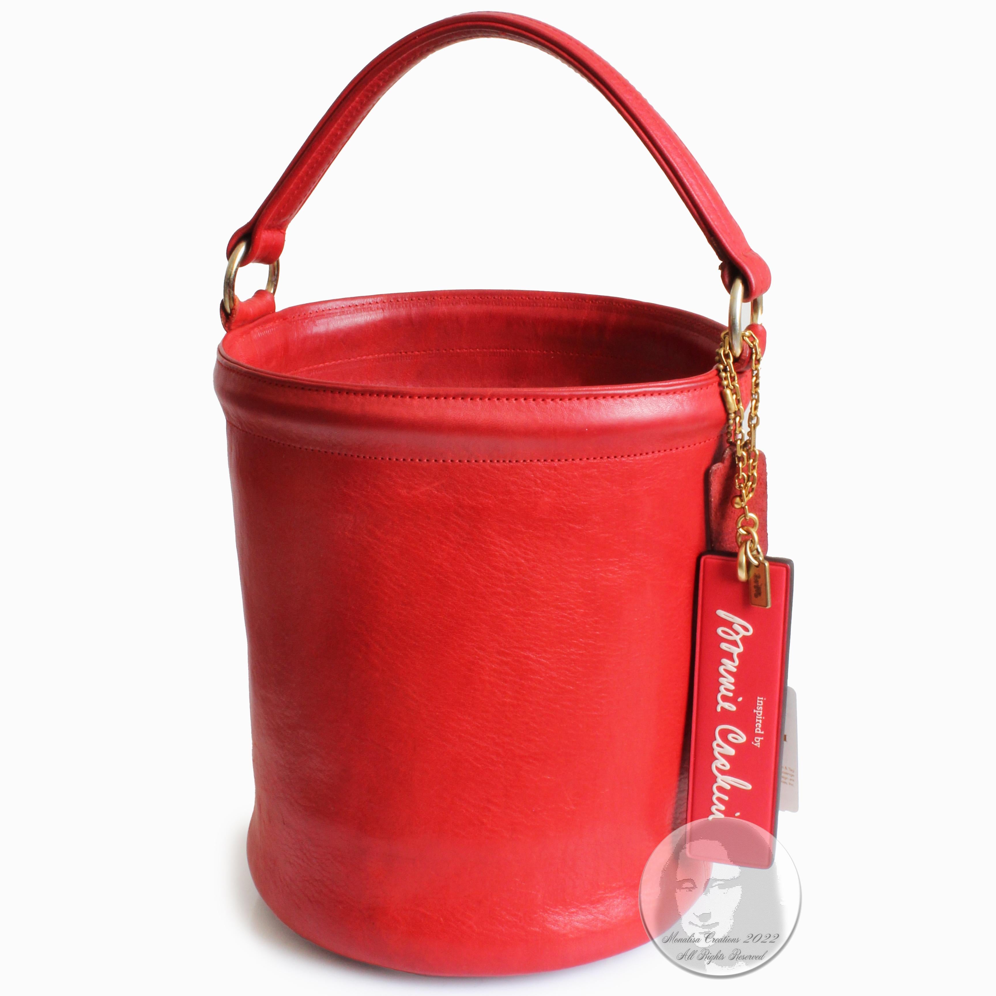 Authentic, preowned, vintage Bonnie Cashin for Coach Feed Bag Bucket Tote, likely made in the 60s.  Made from red leather, it's lined in Bonnie's signature stripe fabric lining with one leather trimmed inner slip pocket, and features four metal feet
