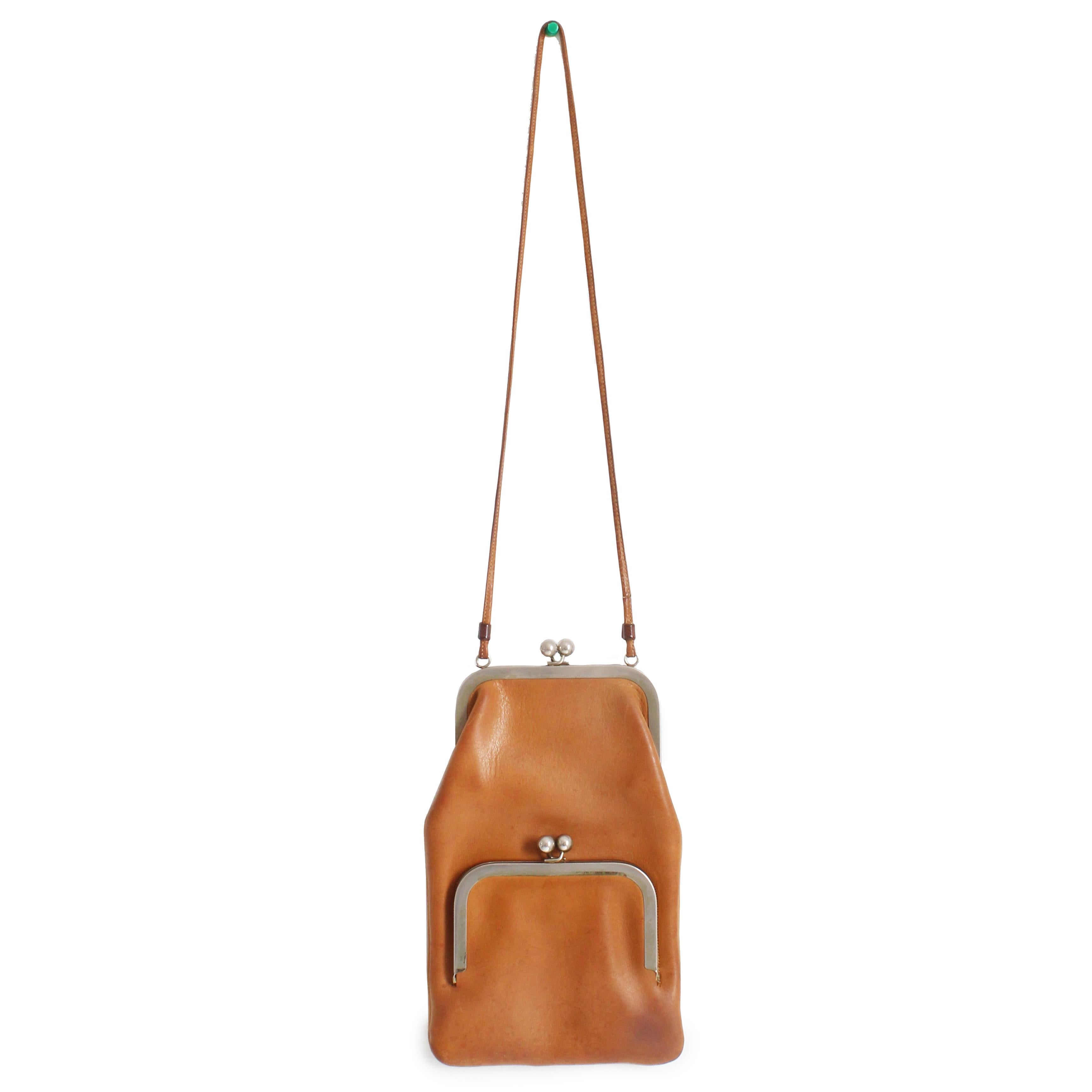 Preowned, vintage Bonnie Cashin for Coach Swinger bag, likely made in the early 70s. Made from patina'd tan leather, it features double frame kiss lock pockets and a skinny shoulder strap. The interior sections are unlined.  

A wonderful Cashin bag