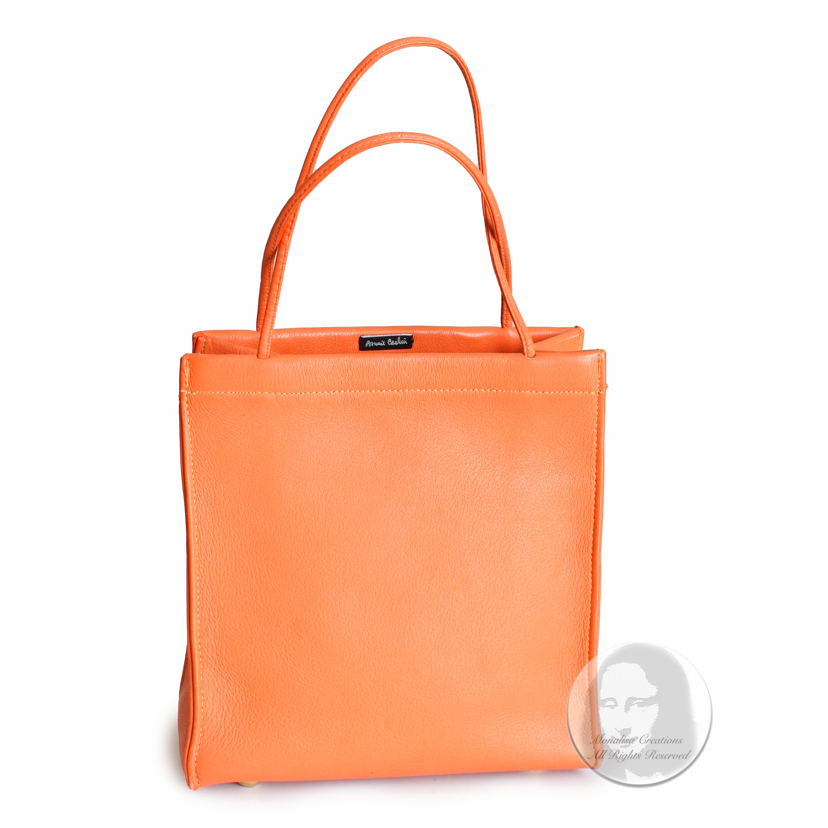 Authentic, preowned, vintage 60s Bonnie Cashin for Coach Mini Tote. A super cool bag in a rare color!! Made from a cantaloupe-hued orange leather, it's lined in Bonnie's signature striped lining and has one slip pocket inside!   

Made in the USA.