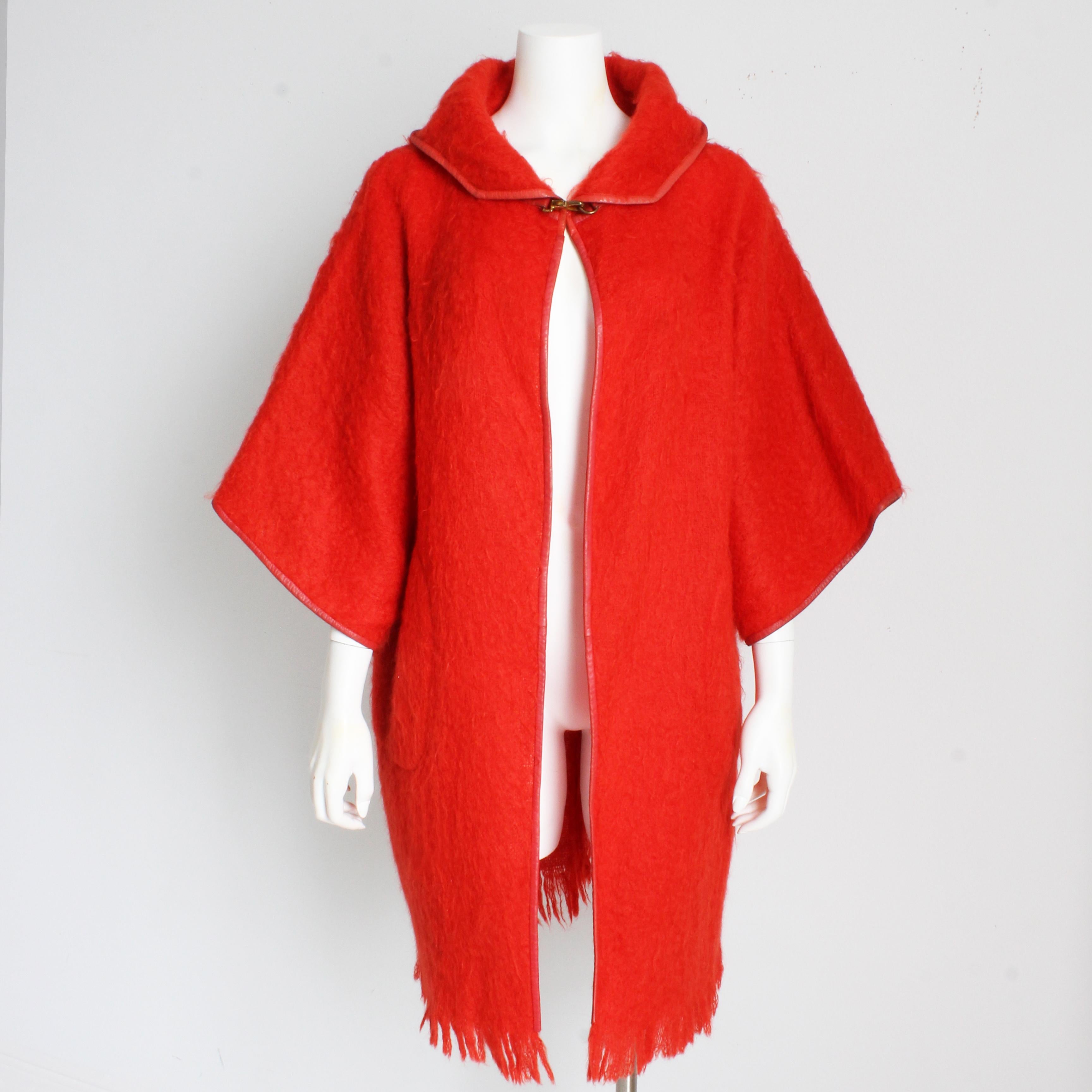 Manteau vintage d'occasion en laine mohair Bonnie Cashin for Sills avec capuche, probablement fabriqué dans les années 1960.  Confectionnée en laine mohair au ton corail brillant, elle est dotée d'une capuche attenante, de manches façon kimono et de