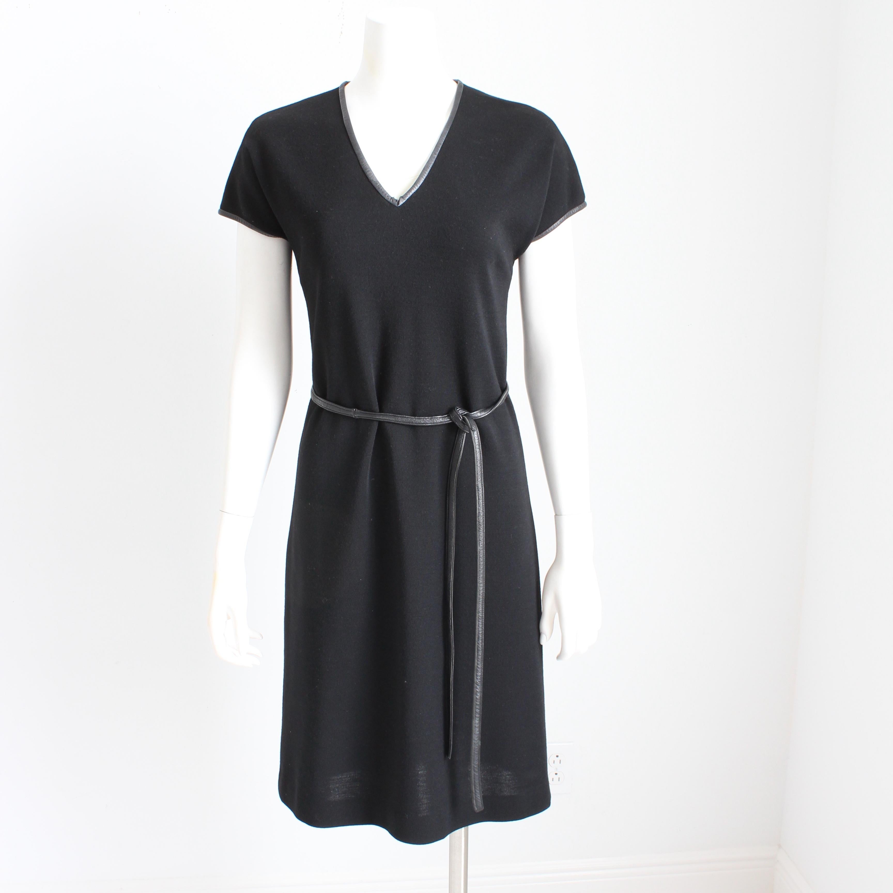 Authentique, d'occasion, robe vintage Bonnie Cashin for Sills en tricot noir à col en V avec ceinture en cuir assortie, vers les années 60. Ultra mod ! 

Confectionné en jersey de laine noir, il présente une encolure en V et des manches capuchon, et