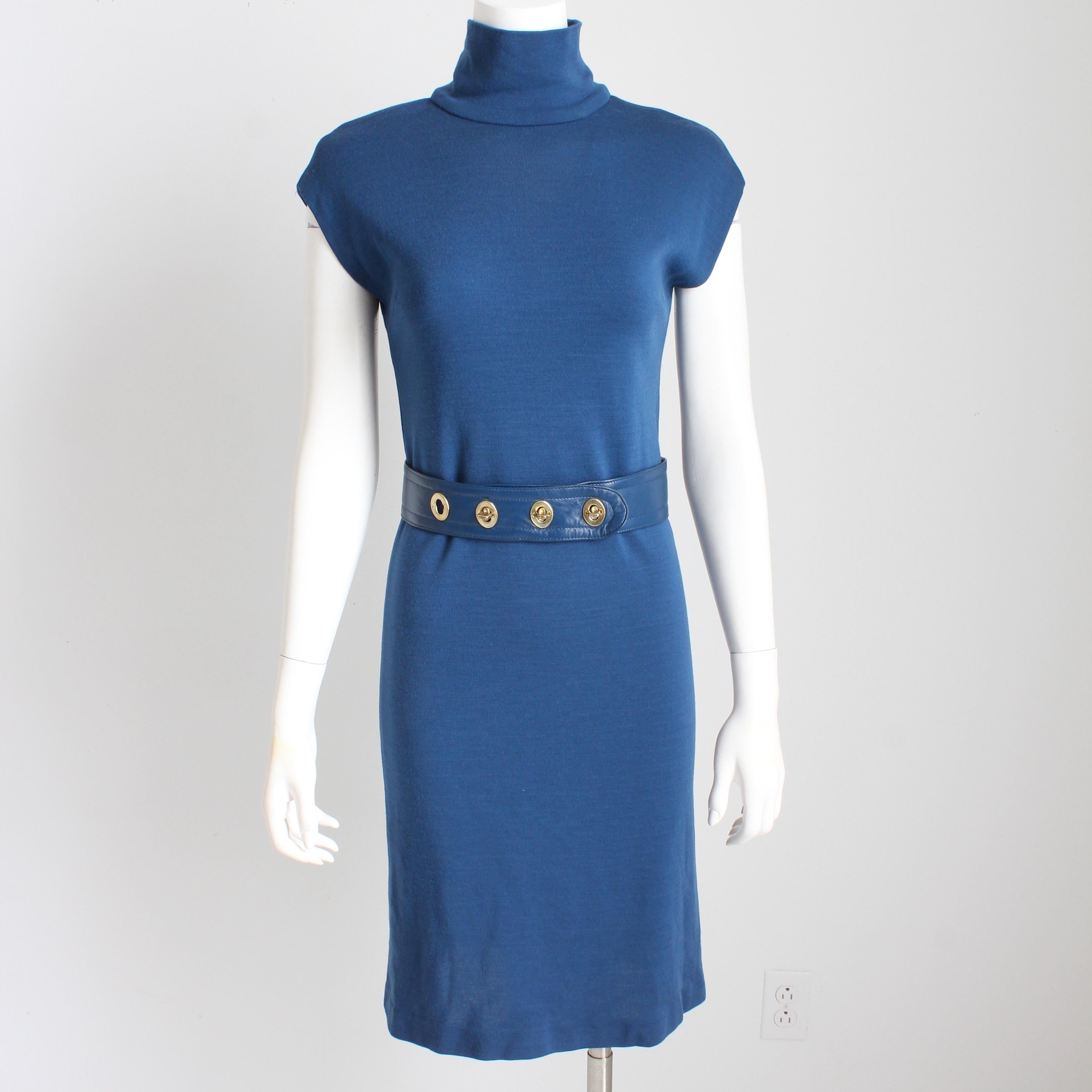 Authentic, preowned, vintage Bonnie Cashin for Sills blue knit turtleneck dress with matching blue leather turn lock belt, circa the 60s. Ultra mod! 

Made from a blueberry-hued wool jersey fabric, it features a high neck, cap sleeves and fastens in