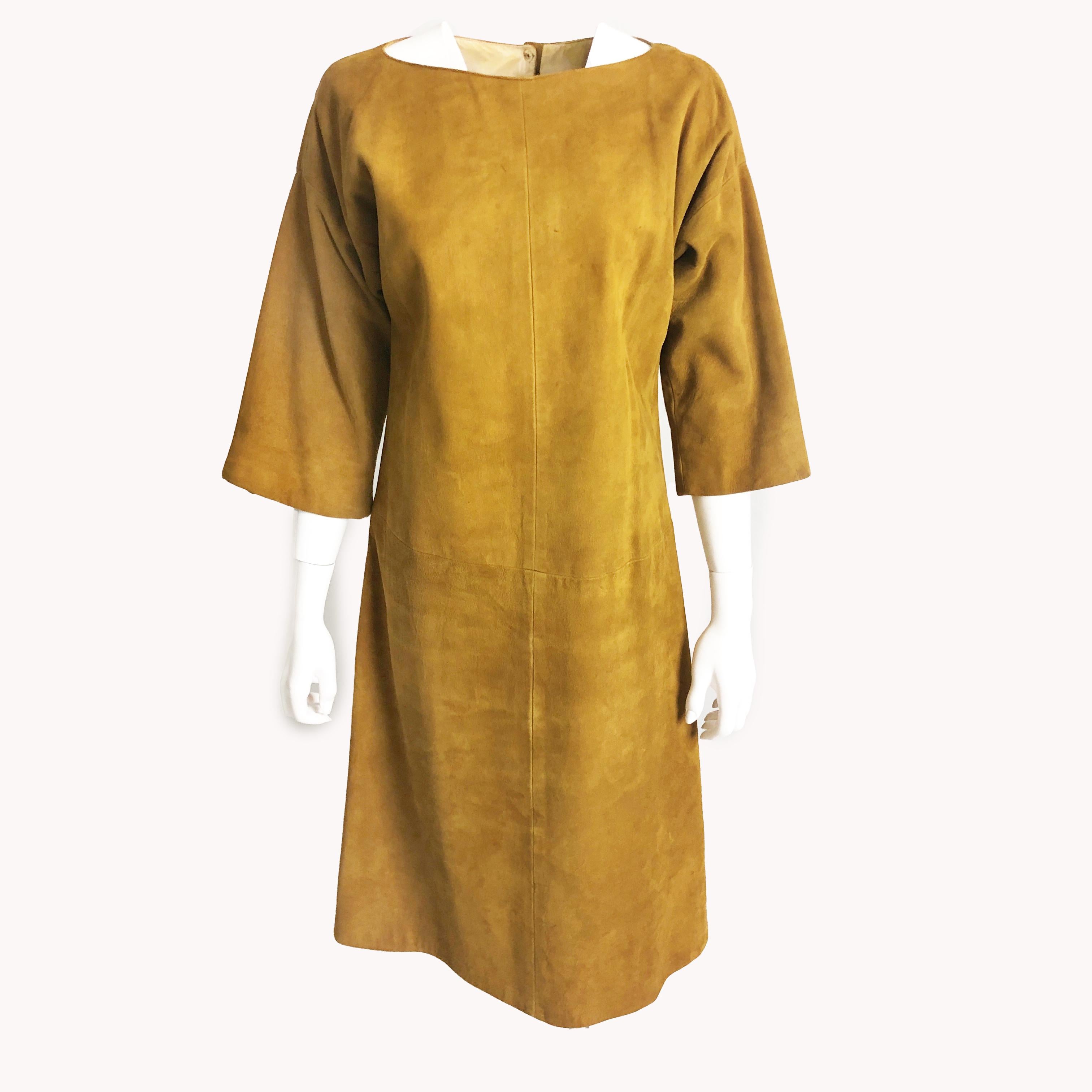 An iconic suede leather dress designed by Bonnie Cashin, and made during her time at Sills in the mid 1960s. Made from an incredibly supple golden-hued suede, it fastens in back with pearlized snaps. Incredibly chic with its wide kimono-style