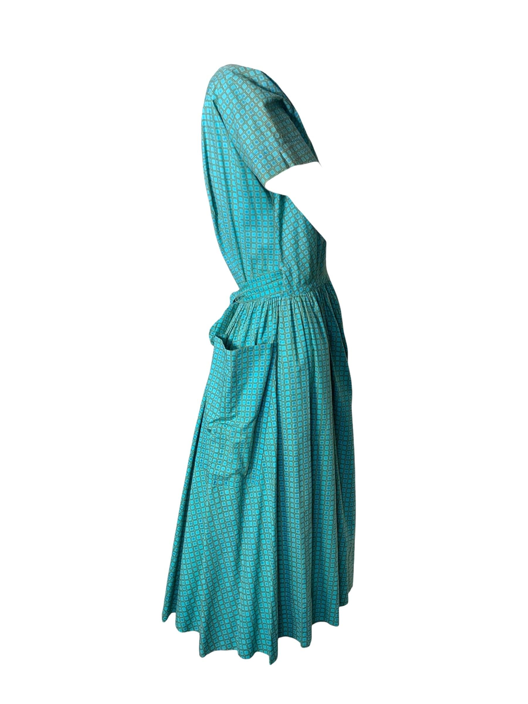 Clásico vestido cruzado de algodón con estampado floral de los años 40, obra del icono americano Bonnie Cashin. Estampado azul turquesa y verde. Cierre envolvente, sin forro. Ligeras zonas de decoloración en toda la superficie. Buen estado vintage.