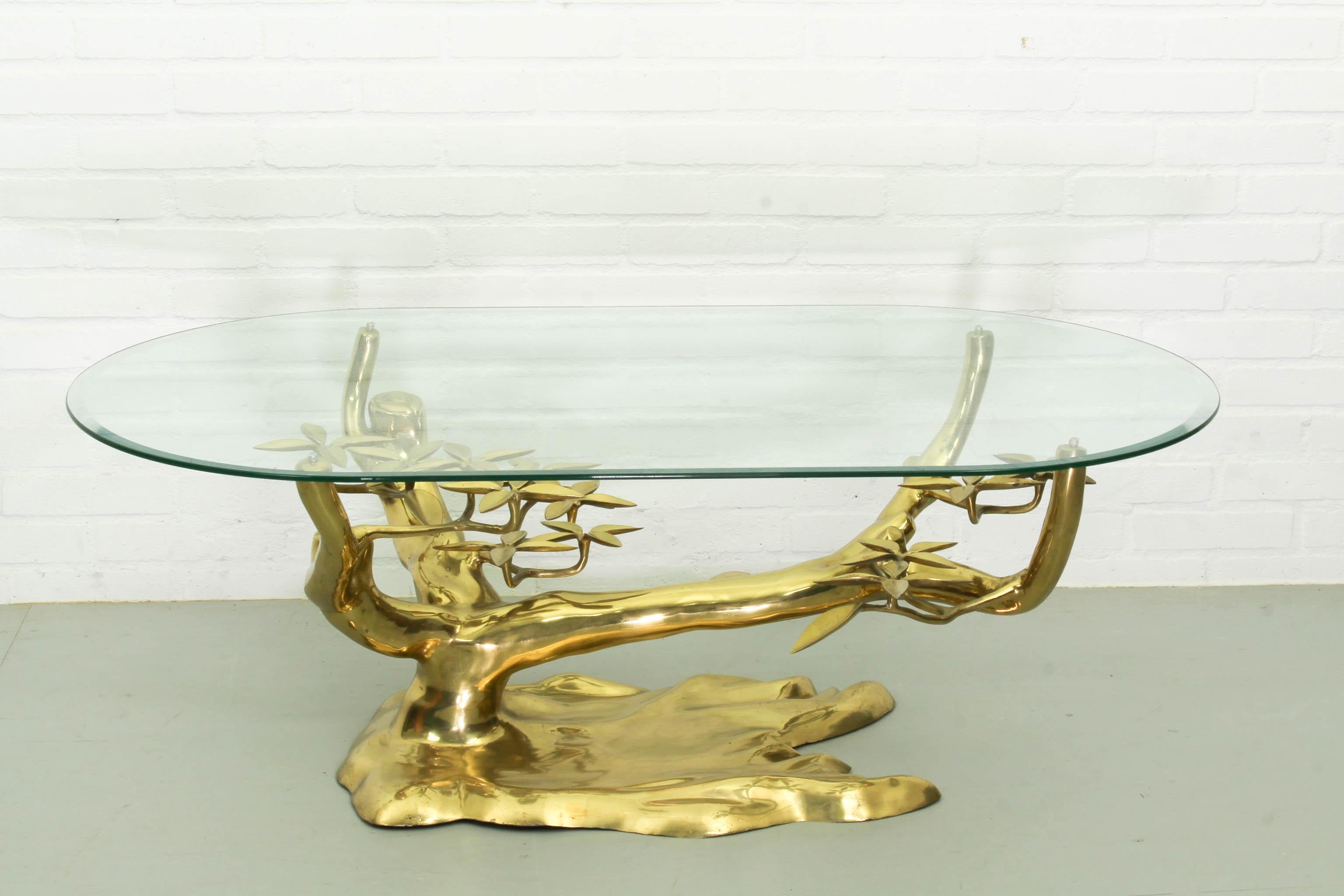 Magnificent Hollywood Regency coffee table in brass designed and produced by Willy Daro, 1970s. The very heavy brass base is shaped as a bonsai tree and topped with an oval glass top with bevelled edge. 

Dimensions: 42cm H, 120cm L and 65cm D.
  