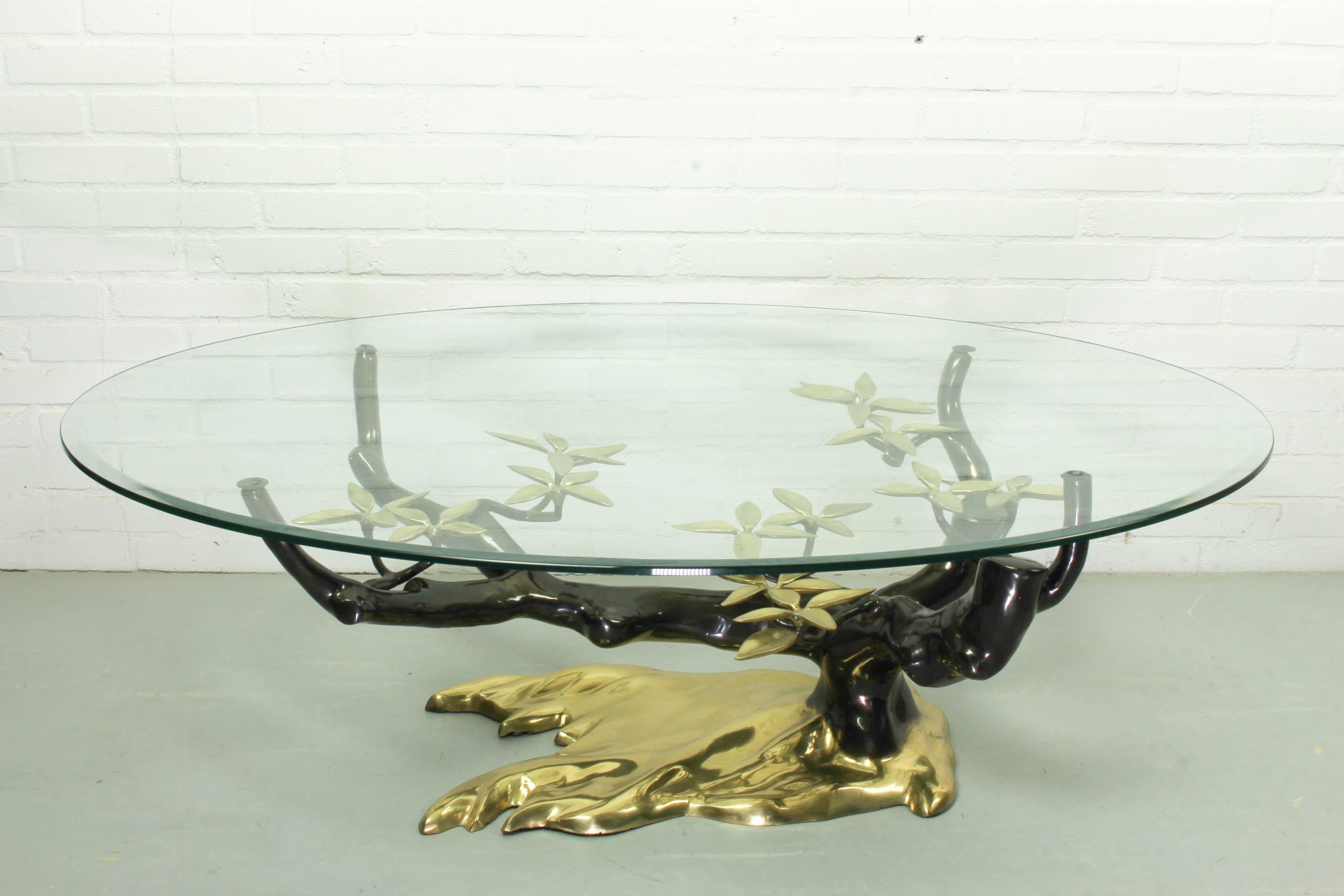 Magnificent Hollywood Regency coffee table in brass Willy Daro, 1970s. The very heavy brass base is shaped as a bonsai tree and topped with an oval glass top with bevelled edge. Dimensions: 42cm H, 130cm L and 90cm D.