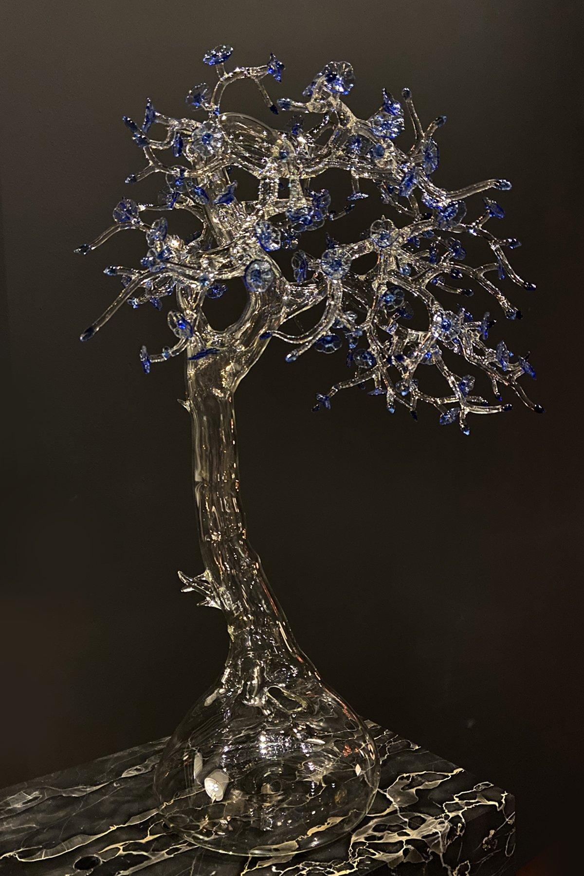 Fire-worked clear and blue borosilicate glass in the form of a miniature tree set atop a bulbous base. Signed and dated on the trunk.
One of a kind-- 