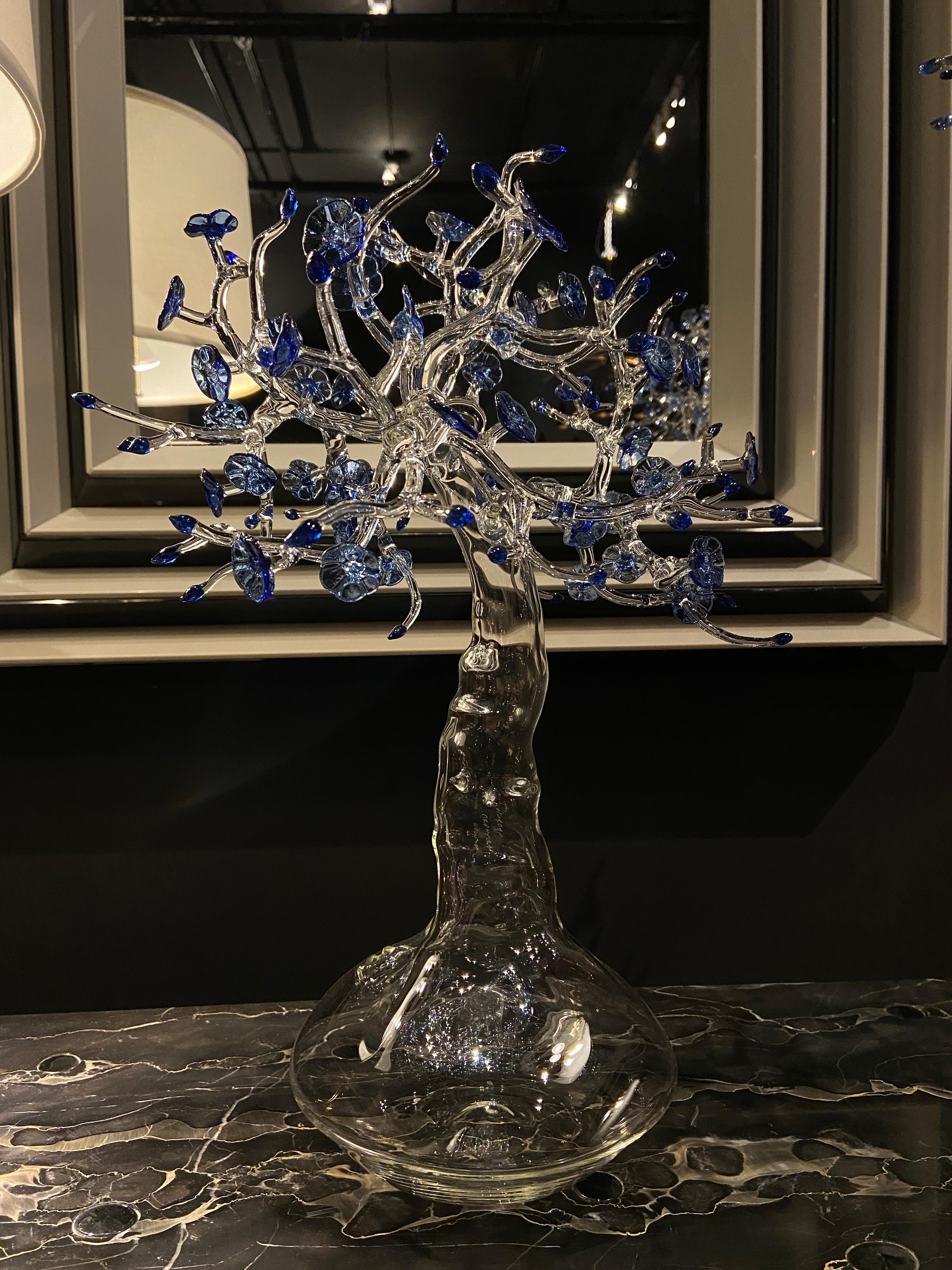 Fire-worked clear and blue borosilicate glass in the form of a miniature tree set atop a bulbous base. Signed and dated on the trunk.
One of a kind-- Certificate of Authenticity included. 

 