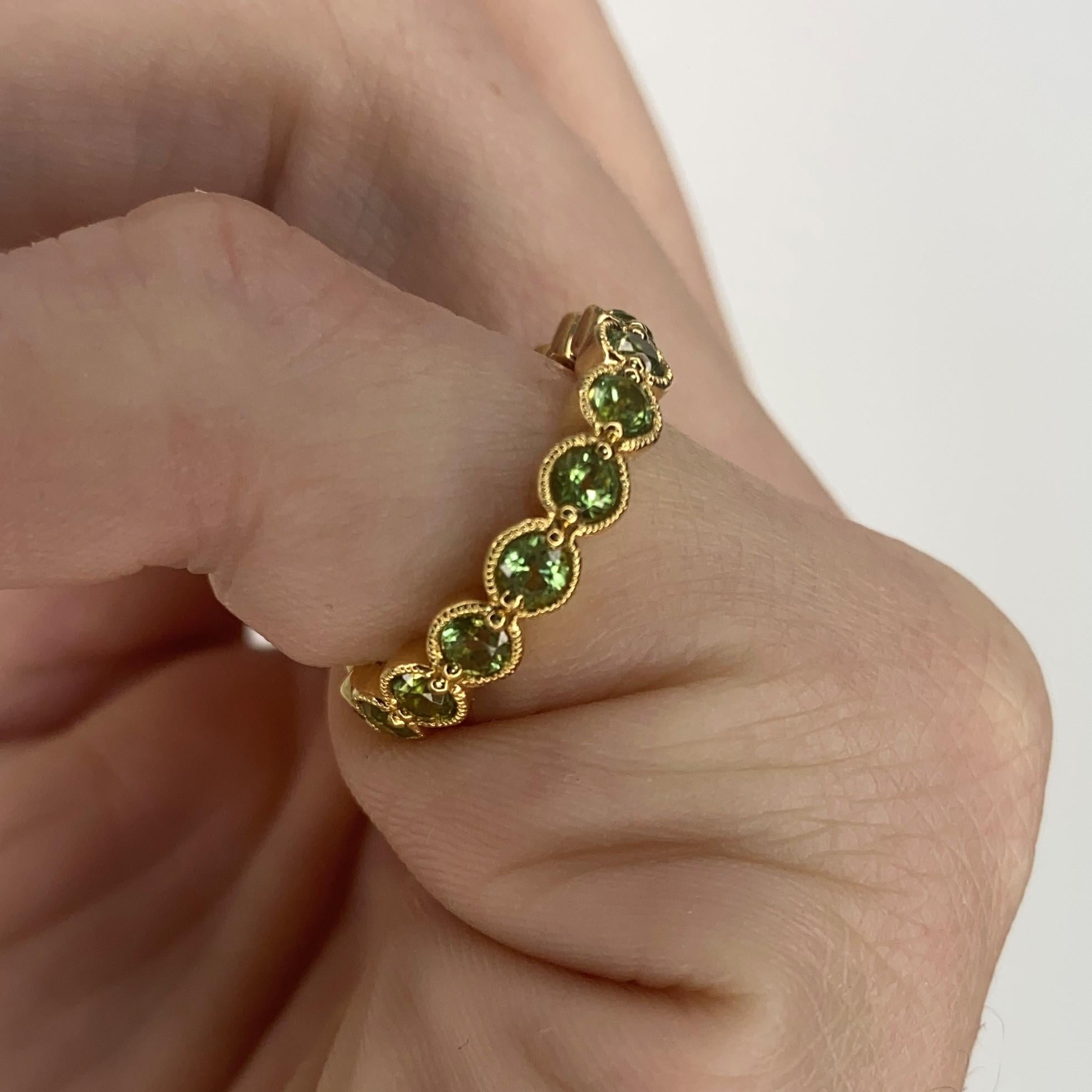 An eternity ring band designed by Bony Levy.

Contemporary eternity band ring crafted by Bony Levy in solid yellow gold of 18 karats with high polished finish. It is mounted in fancy bezel setting with 16 calibrated round brilliant cuts of green