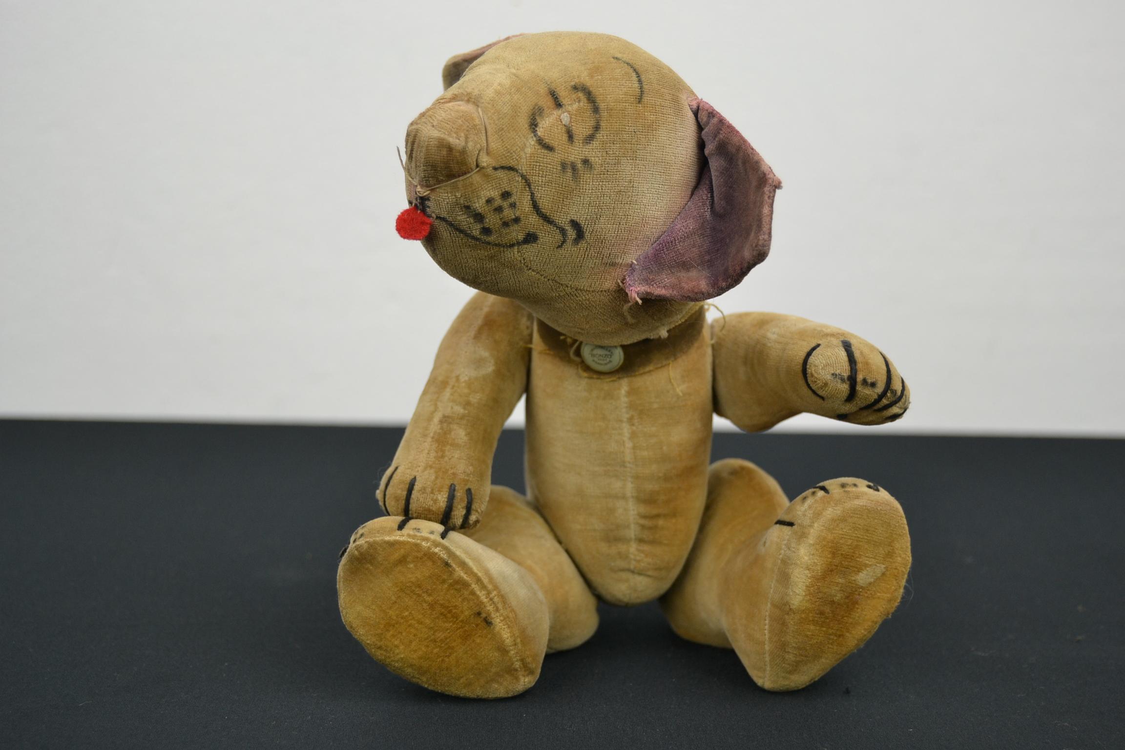 Chad valley comic Bonzo toy dog from the 1930s.
This cream velvet fully jointed Bonzo toy has airbrushed features and a red felt tongue.
He's jointed at neck, shoulders and hips, has stitched claws and still wears his original collar with Chad