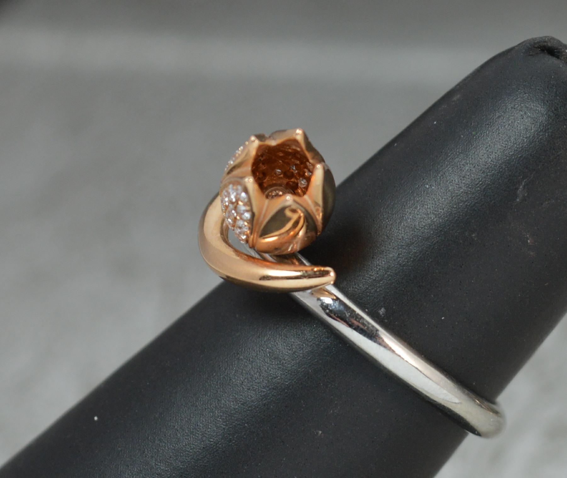 A stunning Boodles ring forming part of the Maymay range, tulip design.
Solid 18 carat white gold shank with rose gold tulip and leaf front.
Designed with grain set round brilliant cut diamonds to the front of the band, the flower and inside the