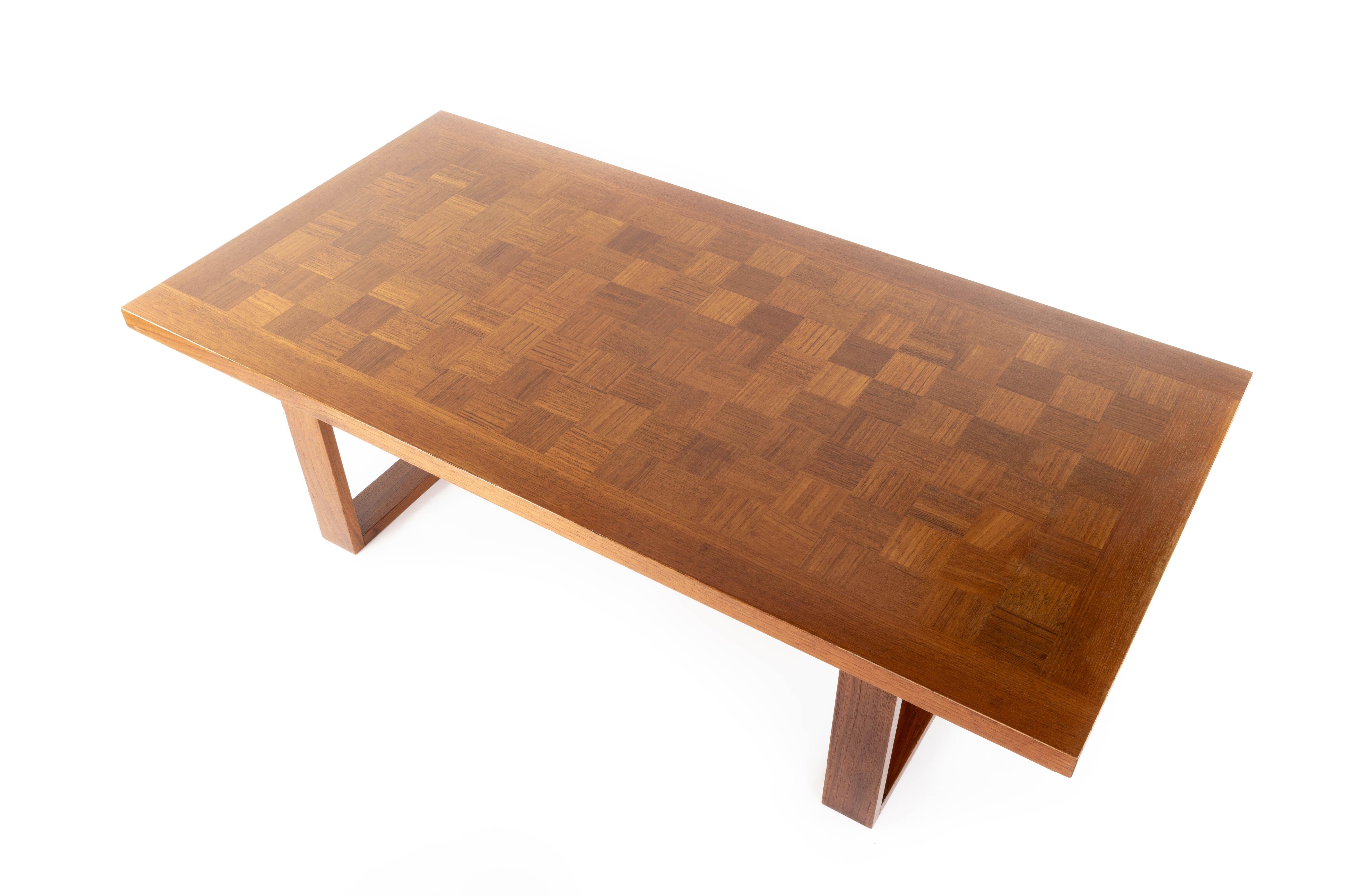 Large coffee table, sometimes called Boggie Woogie chess tables. This teak parquet table sit on two sled legs. Rectangular model
With its metallic label of the numbered and embedded mark on the back of the board.
Measurements:
Total height 40