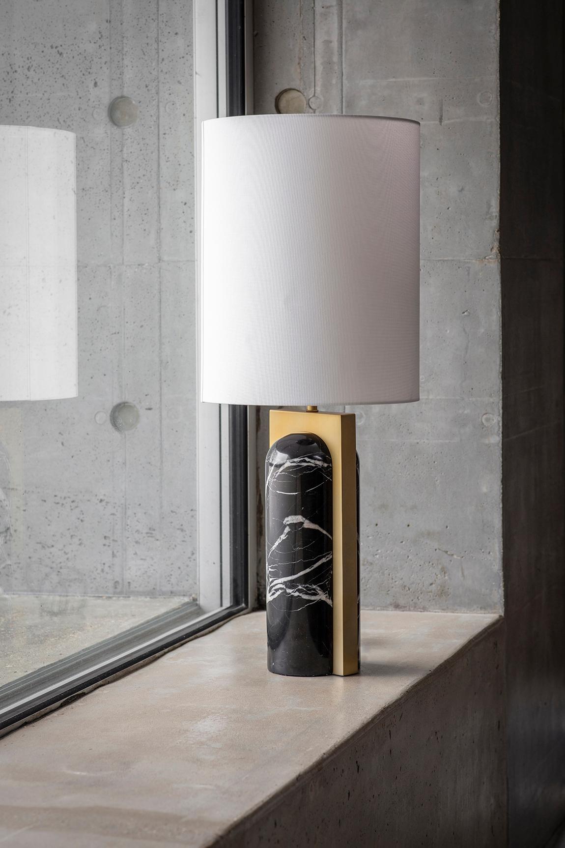 Book Ends Table Lamp by Square in Circle
Dimensions: D35 x H84 cm
Materials: Brushed brass/ black marble/ white cotton shade
Other finishes available.

The refined contemporary style of this table lamp is crafted from a tapered and rounded black