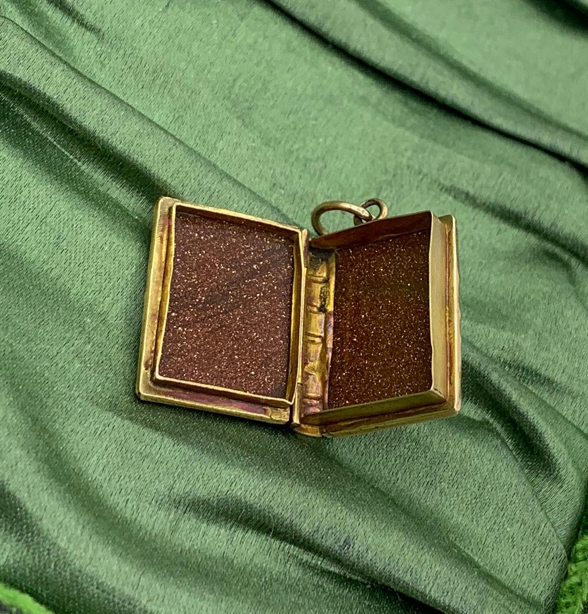 THIS IS A CLASSIC BOOK FORM  VICTORIAN PICTURE LOCKET PENDANT OR CHARM IN SOLID 14 KARAT GOLD WITH BEAUTIFUL NATURAL GOLDSTONE FRONT AND BACK!
The solid 14 Karat gold locket with Goldstone front and back in the form of an opening book is just