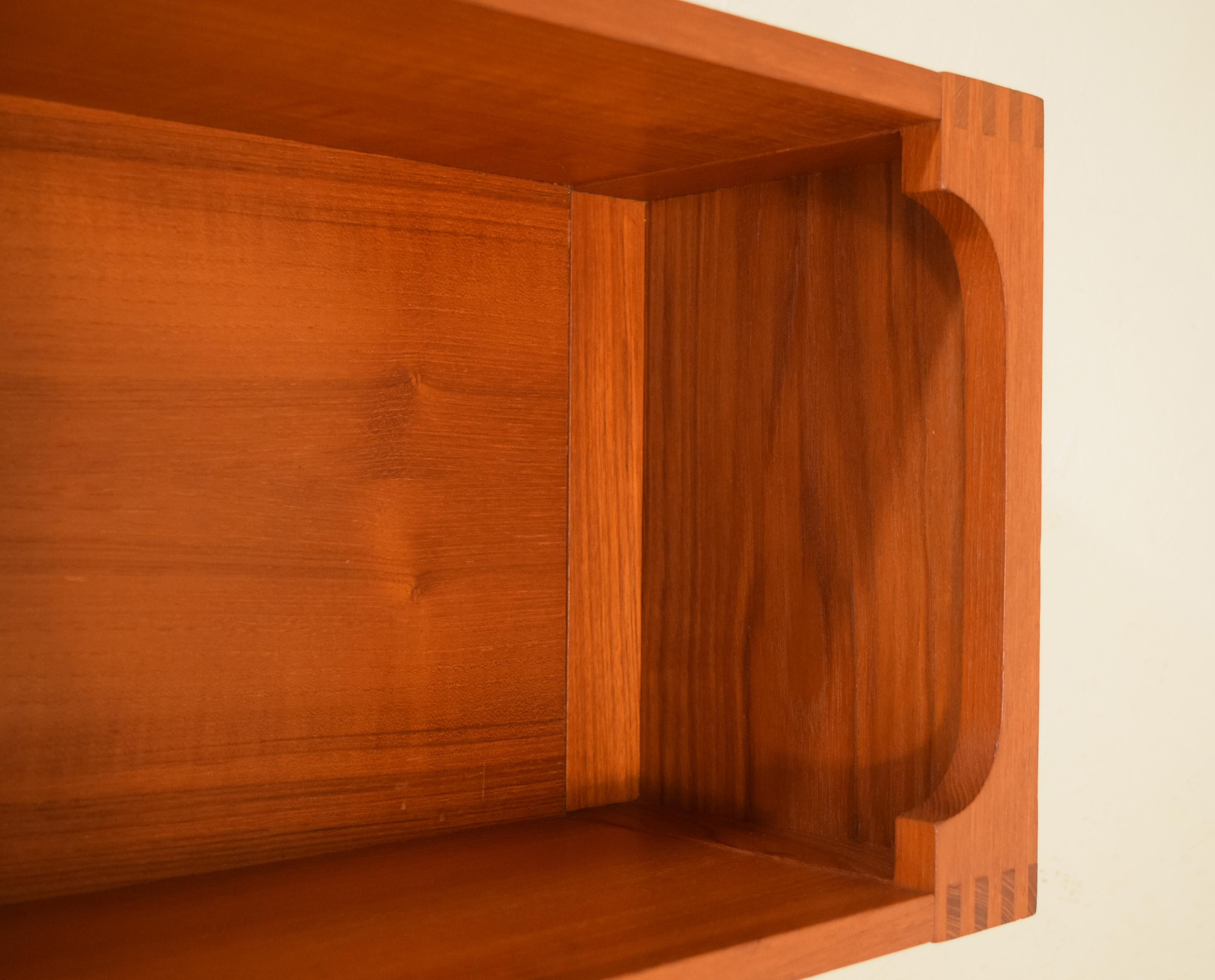 Teak book shelf by Pedersen & Hansen of Denmark with fine dovetailing to both ends with mounting holes to the rear. Perfect for small display of objects and books in limited sized spaces with bottom and top shelves for use. Scandinavian Modern