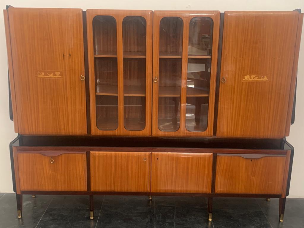 Double-bodied bookcase display case by Vittorio Dassi, rosewood veneered with ebonized profiles, mahogany details, brass tips, black glass. The moved sides support the body of the cabinet at the base 4 doors, the side doors and handles in mahogany