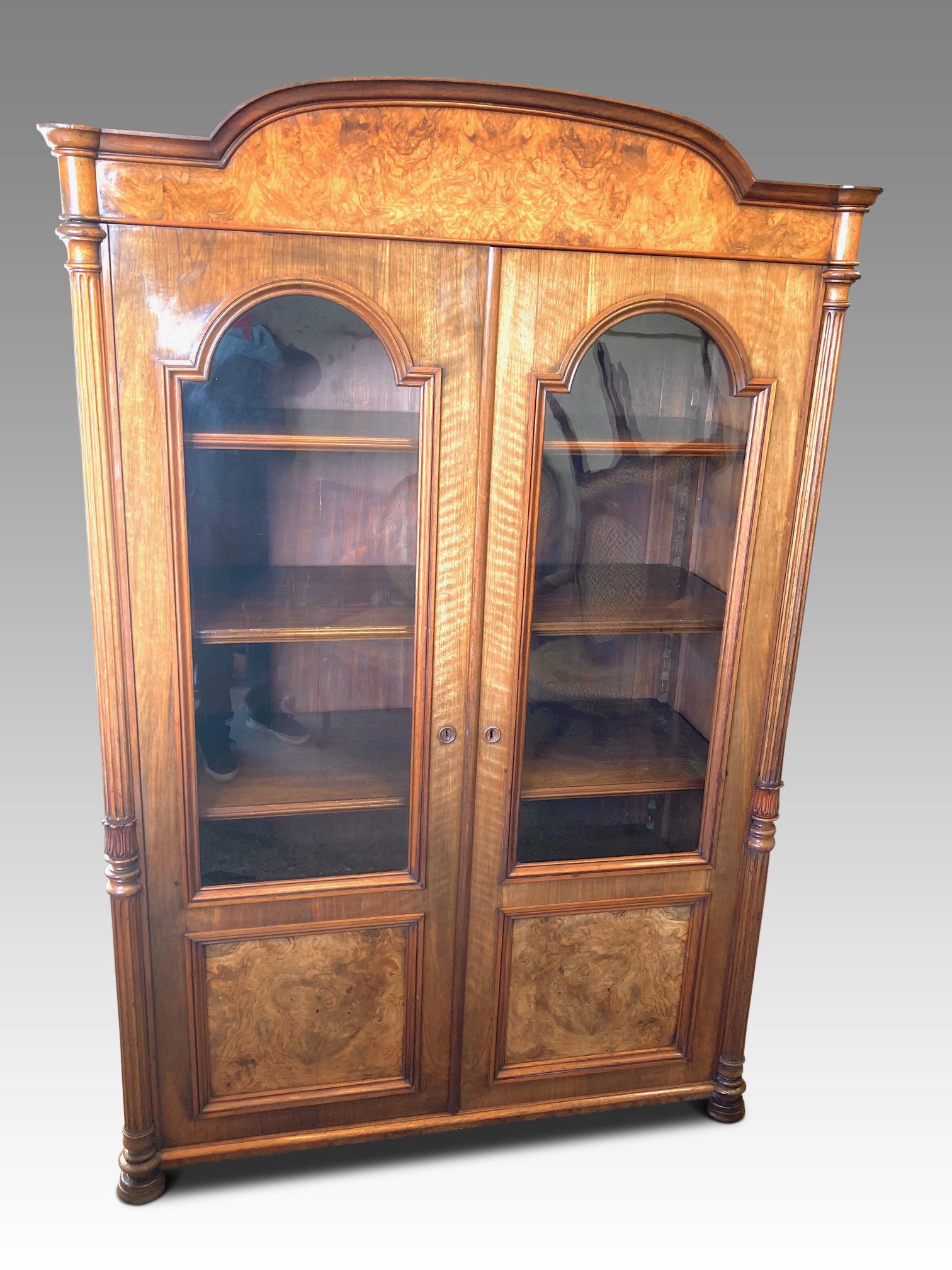 Attractive walnut cabinet / bookcase from the late 19th century. 
This delightful bookcase is of solid construction with figured walnut veneers
on oak and an all-over mellow colour and antique patination. Working key. 
There are 2 glazed doors
