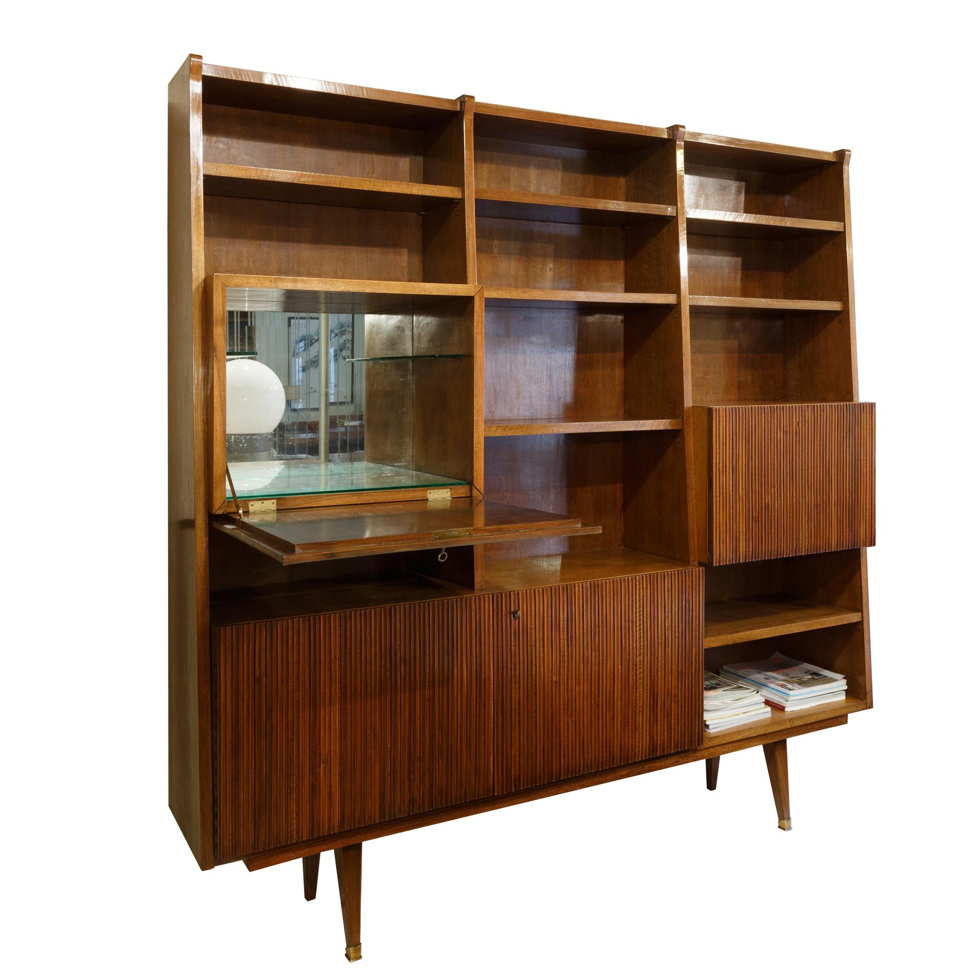 Bookcase and writing desk and bar area in grissinato walnut wood, in style Gio Ponti, Italy 1950s, Mid-Century Modern.
The door that opens the pretty bar, which inside is finished in mirror, the door is in parchment and has original metaphysical