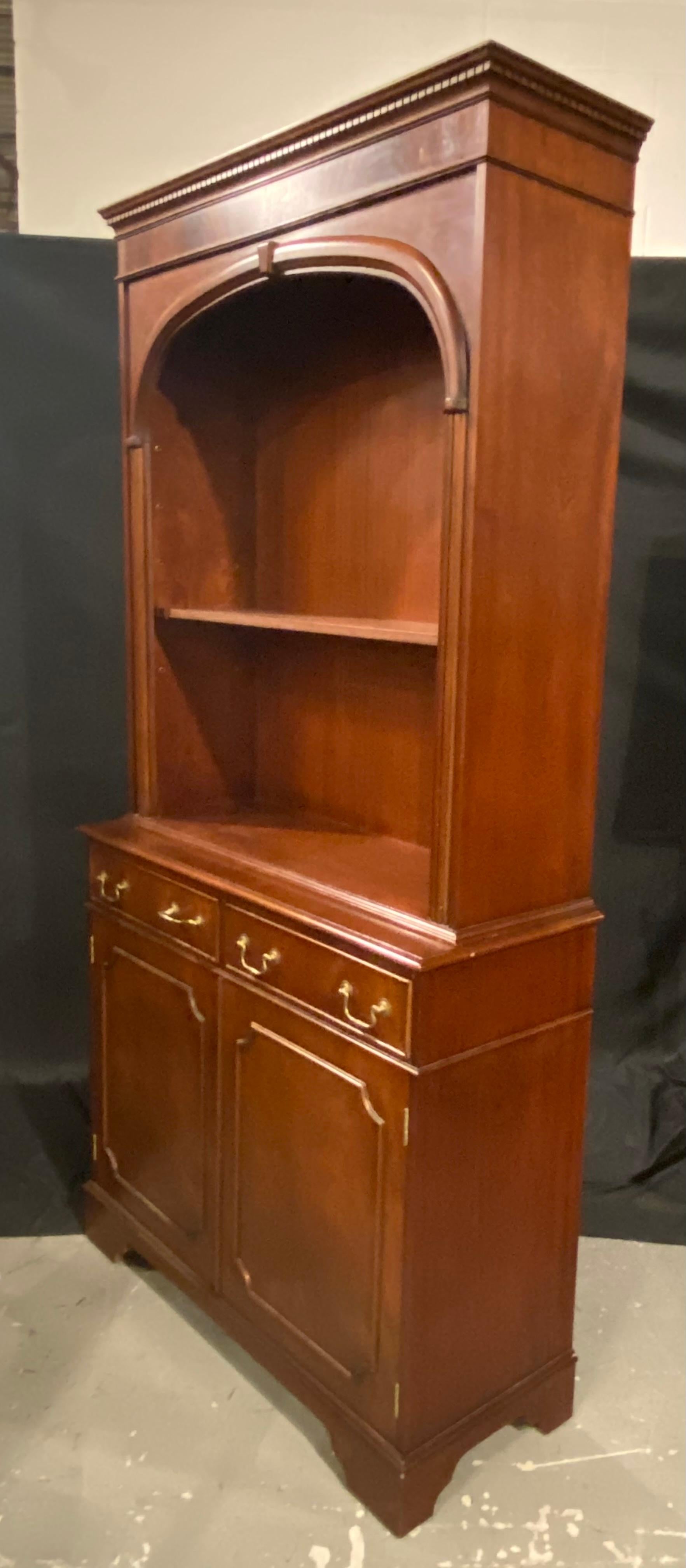 A traditional English bookcase in the Georgian styling, with a Classic arch in the top of the bookcase shelf area. The cabinet is in two pieces top and bottom with the booth being server type cabinet.