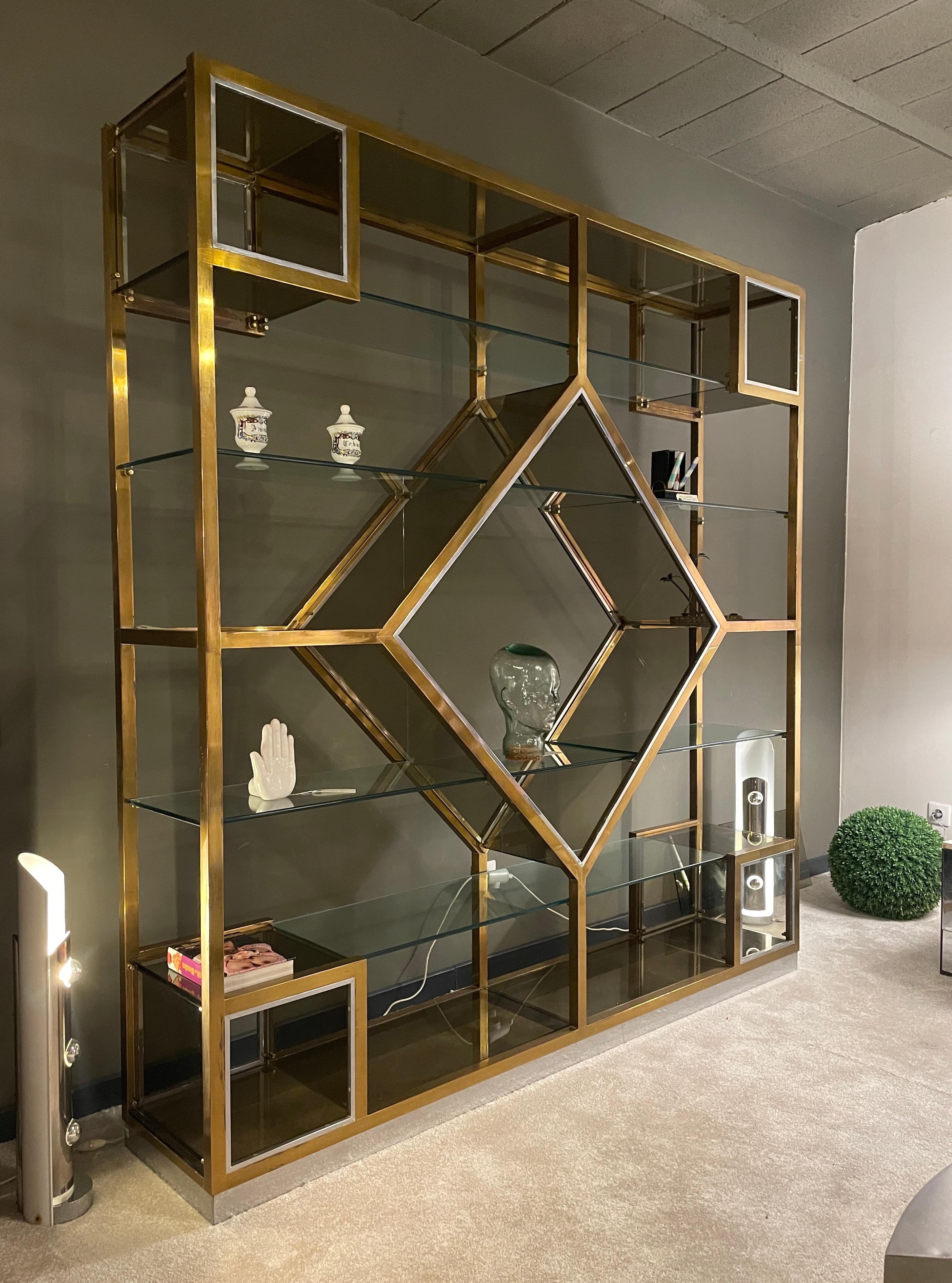 Bookcase, Etagere by Romeo Rega. Geometric shelving system.
Romeo Rega is a famous Italian designer. His work is inspired by Willy Rizzo, Kim Moltzer, Gabriella Crespi.
Spectacular brass and glass shelf.
1970s.
20th century.
Can be partially