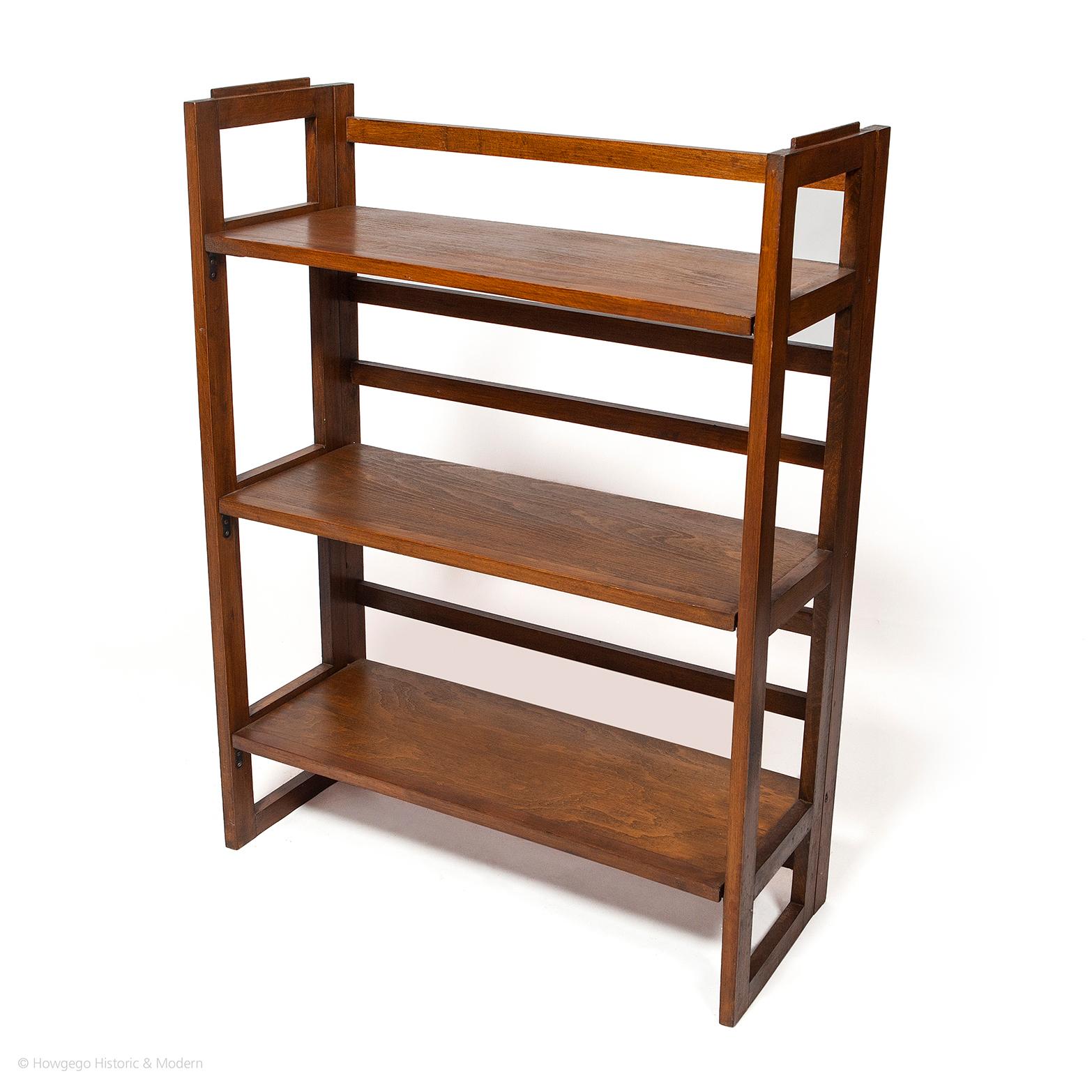 An unusual and ingenious, mid-century modern retro, portable, folding table top bookcase or display shelf. Slatted supports with three shelves folding flat. Light and easy to carry. 
Versatile folding mechanism for display, books or bathroom