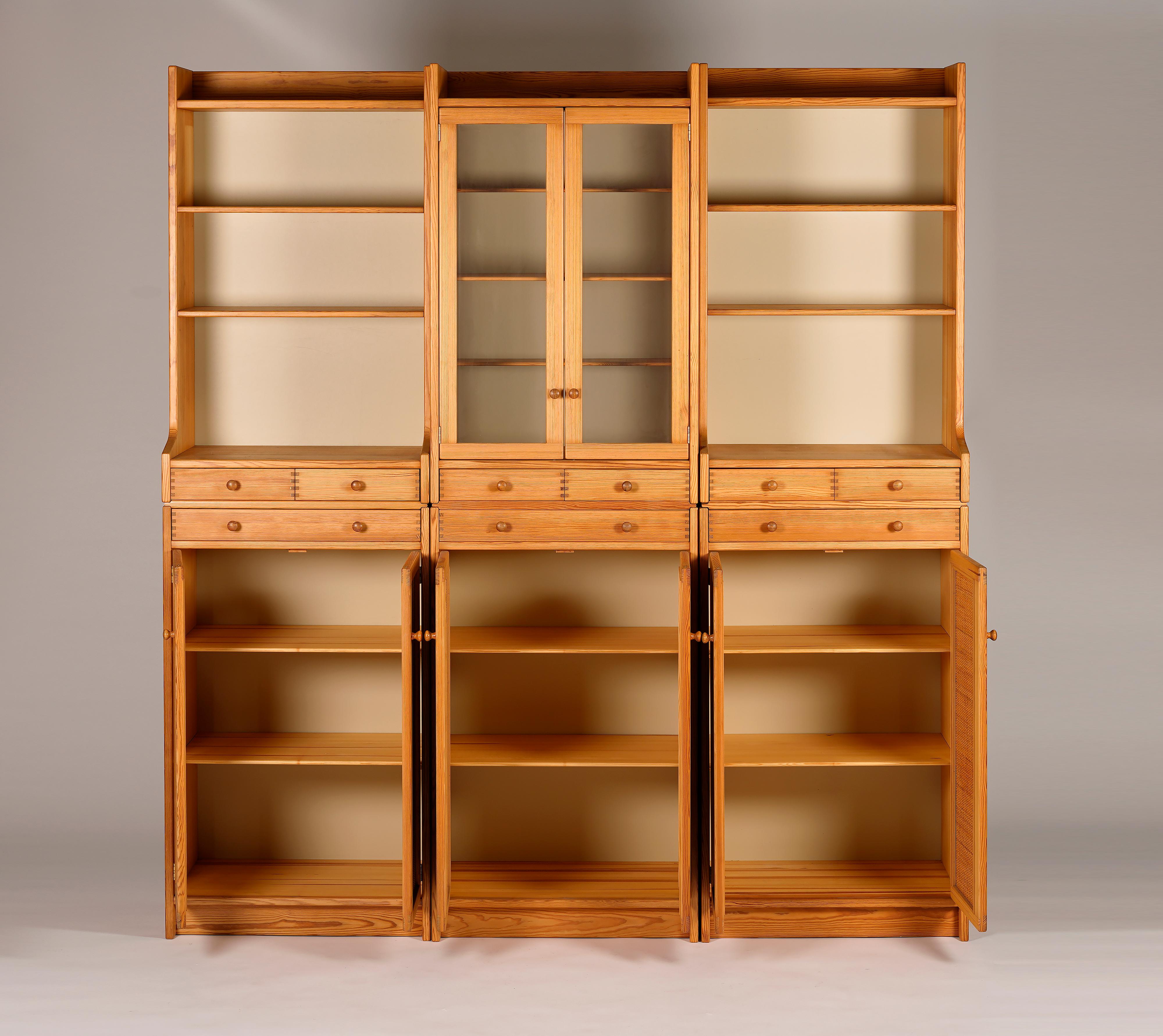 Bibliothèque en trois parties en pin massif et portes en rotin. Conçu par Yngve Ekström pour Swedese dans les années 1970. La bibliothèque contient six modules. Facile à arranger comme vous le souhaitez, avec ou sans les pièces supérieures. Chaque