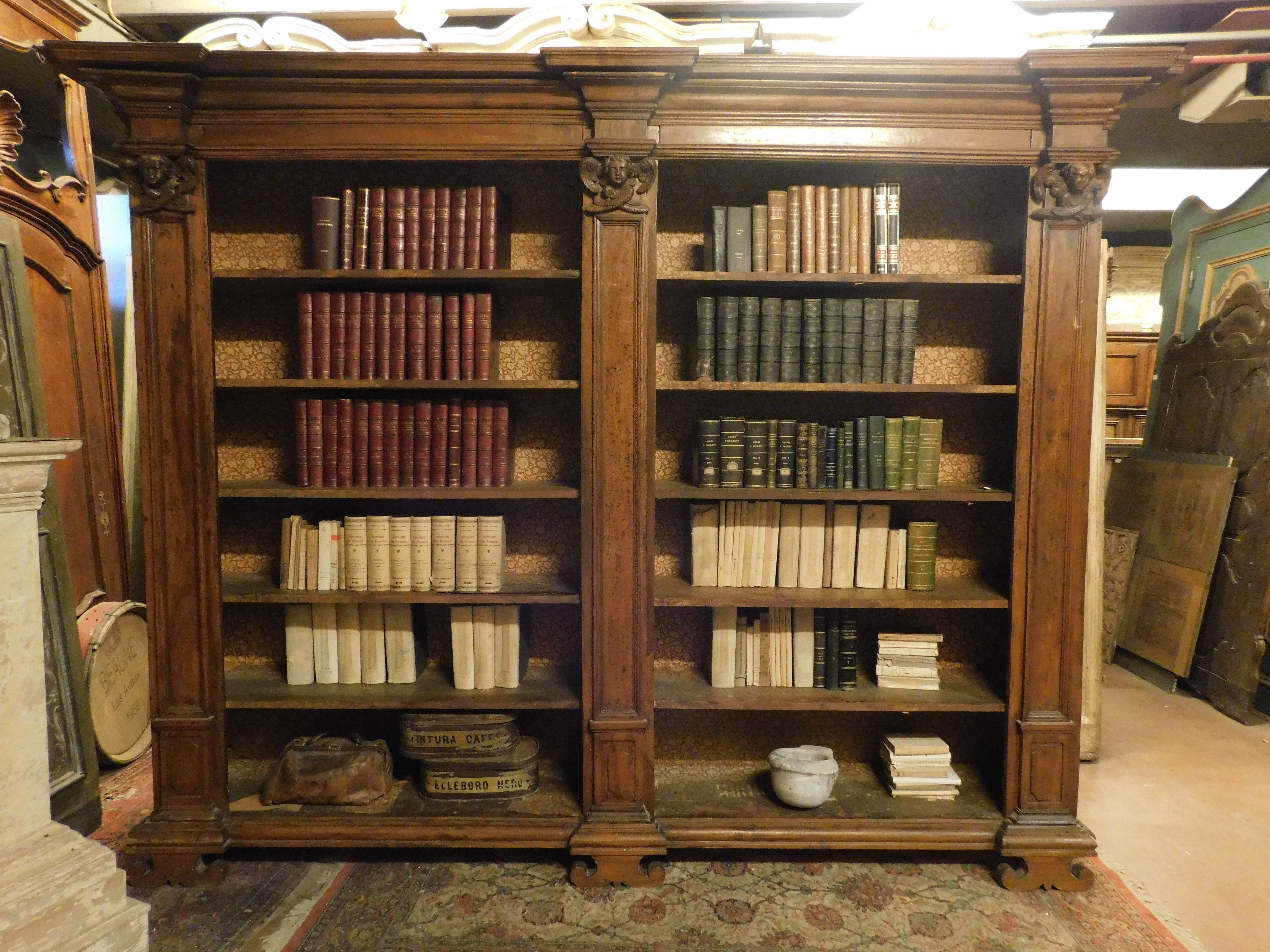 Grande e antica libreria in legno di pioppo massiccio, patinato e intagliato con colonne e putti, molto capiente e solida, di bella presenza scenica e di grande valore storico, elegante e raffinata, proveniente dall'Italia, originale del XVIII