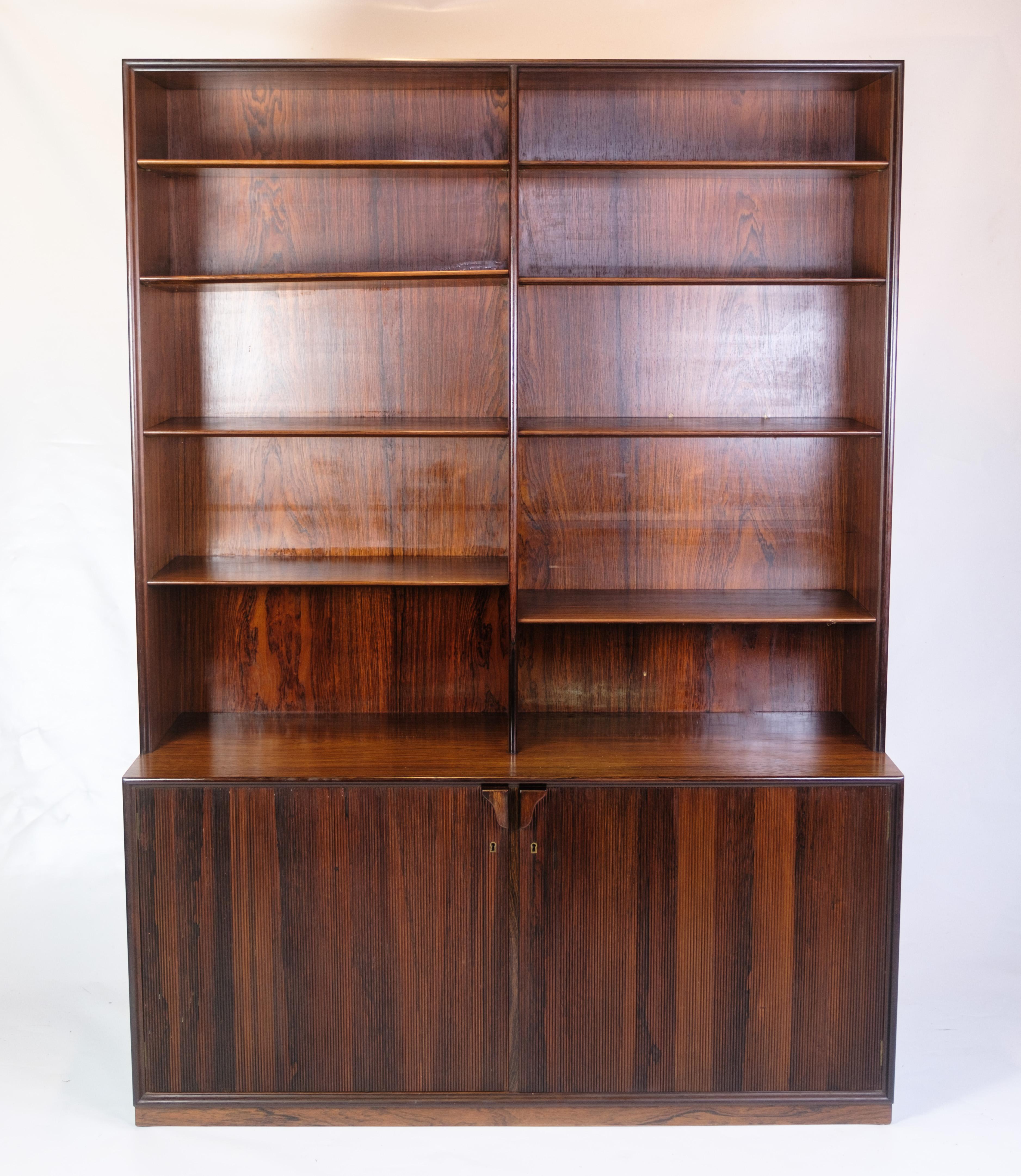 Libreria alta in palissandro, disegnata da I. Holm e venduta da Illums Bolighus negli anni '60. Realizzato con ripiani regolabili e armadietti di base con chiavi e maniglie dal design accattivante. La struttura scura e vibrante delle venature e il