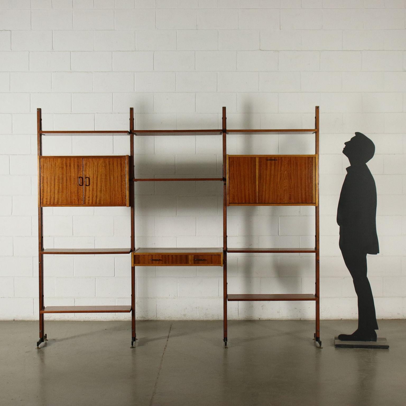 Bookcase with elements with adjustable position. Uprights in wood and metal, shelves and containers in mahogany veneered wood.