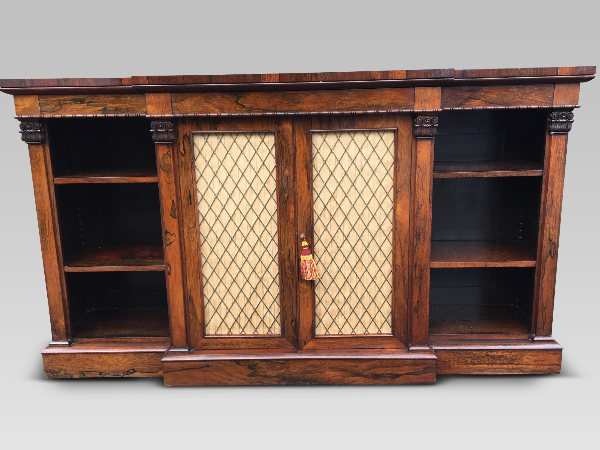 Fine quality English rosewood bookcase from the Regency period.
This delightful bookcase has strongly grained rosewood veneers, crisp features and a deep rich finish with patination.
There are 6 adjustable shelves. The central breakfront has a