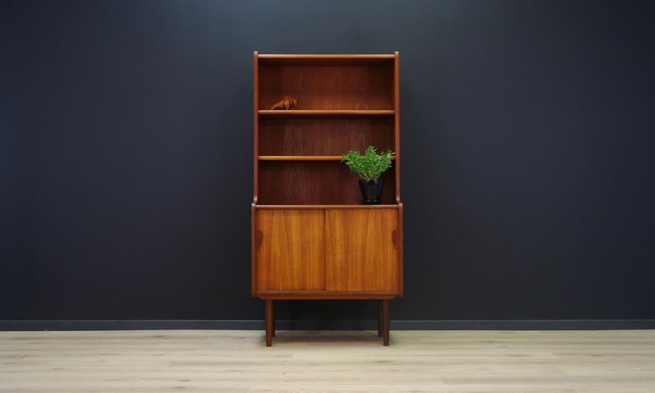 Fantastic bookcase from the 1960s-1970s, minimalistic form, Scandinavian design. The form veneered with teak. Spacious space with a shelf behind a sliding door. Preserved in good condition (minor scratches and dings, filled veneer loss), directly