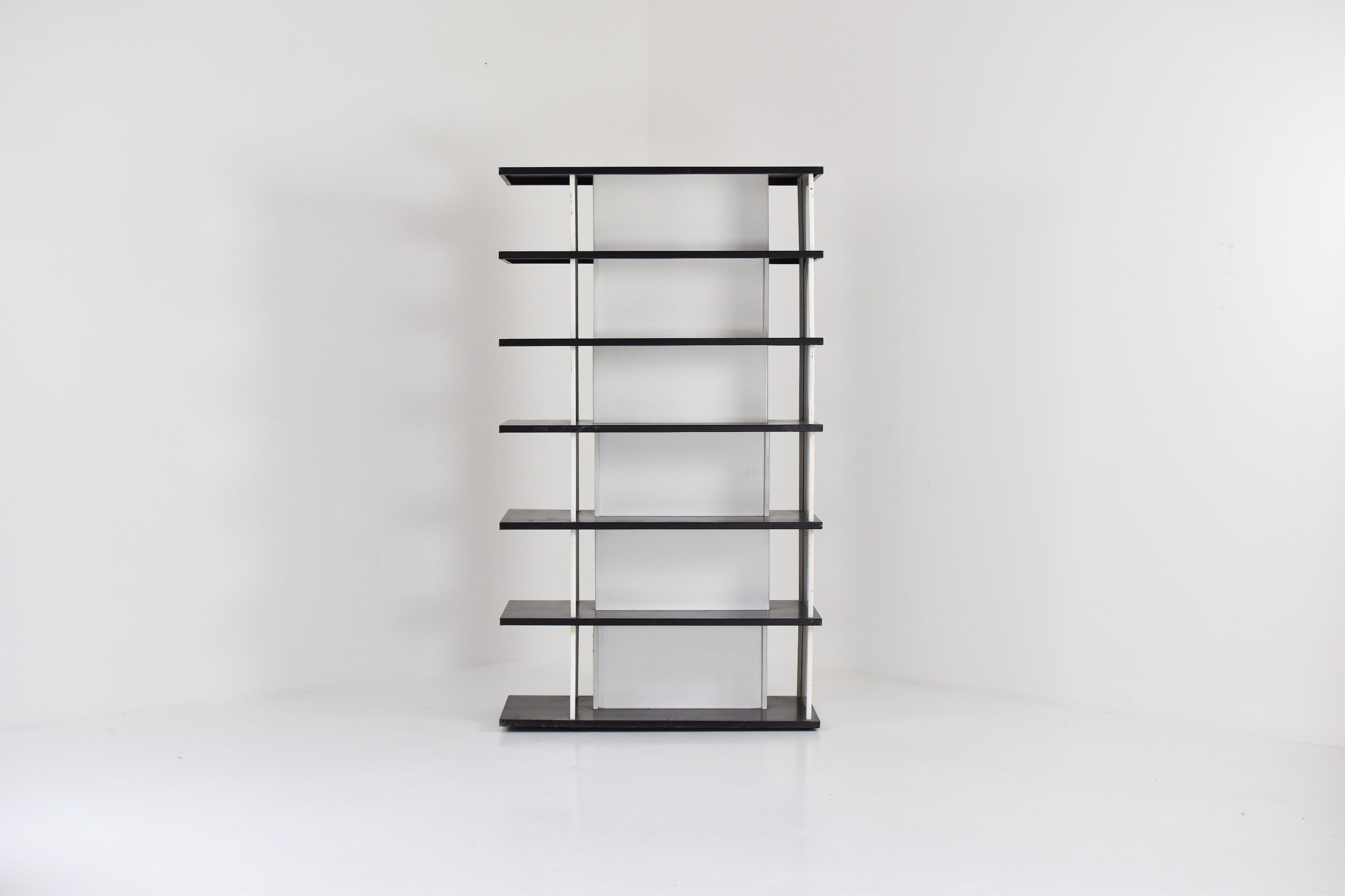 Impressive bookcase / room divider designed by Wim Rietveld for De Bijenkorf, The Netherlands 1960’s. This bookcase stands on its own, its double sided so you can also use this as a room divider. This bookcase has its original black and white color.