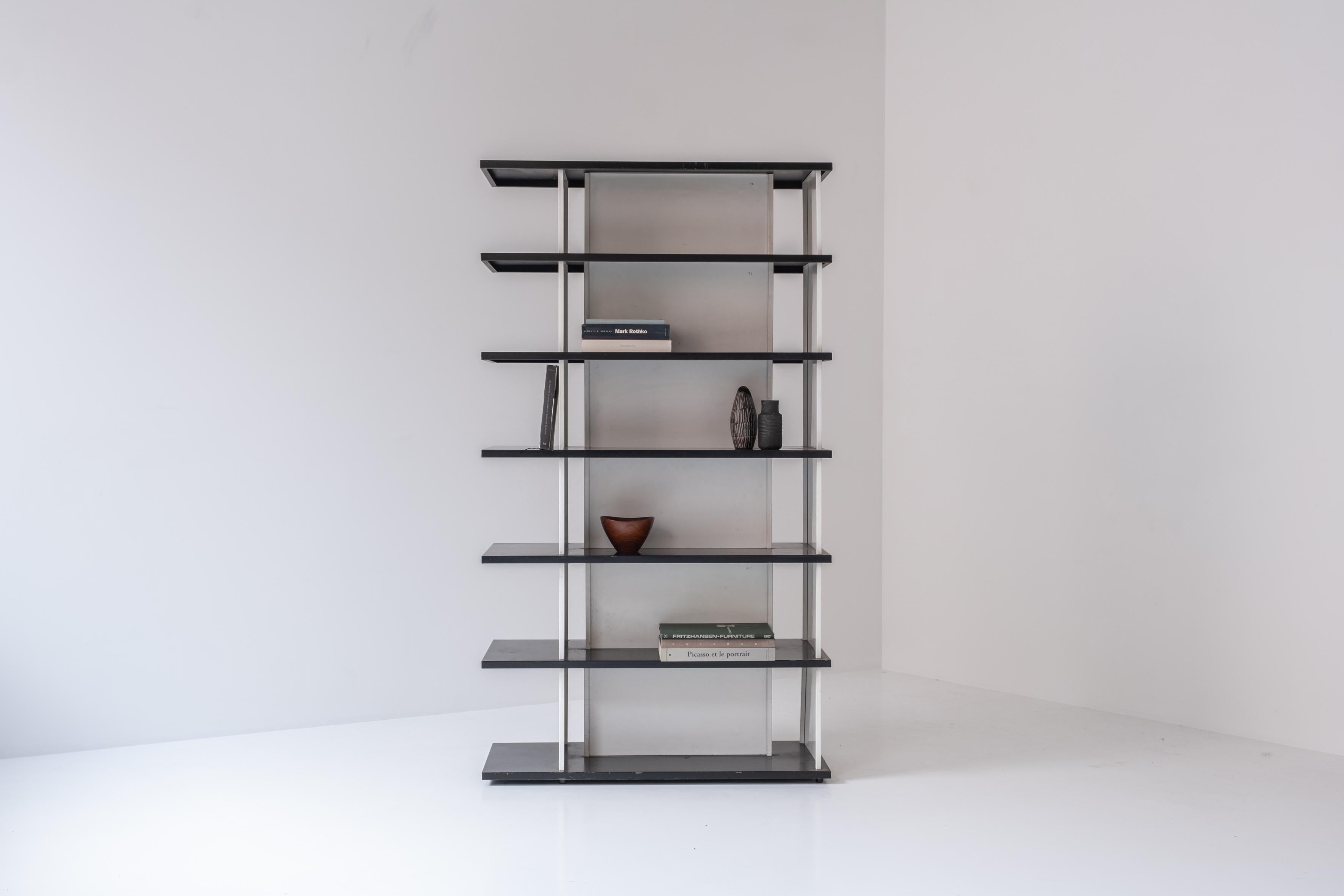 Impressive bookcase / room divider designed by Wim Rietveld for De Bijenkorf, The Netherlands 1960s. This bookcase stands on its own, its double sided so you can also use this as a room divider. It has its original black and white lacquered color.