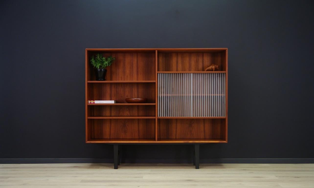 A functional bookcase - library from the 1960s-1970s, a minimalistic form - Danish design. Bookcase finished with teak veneer. An additional advantage is elegant glass. Preserved in good condition (small dings and scratches) - directly for