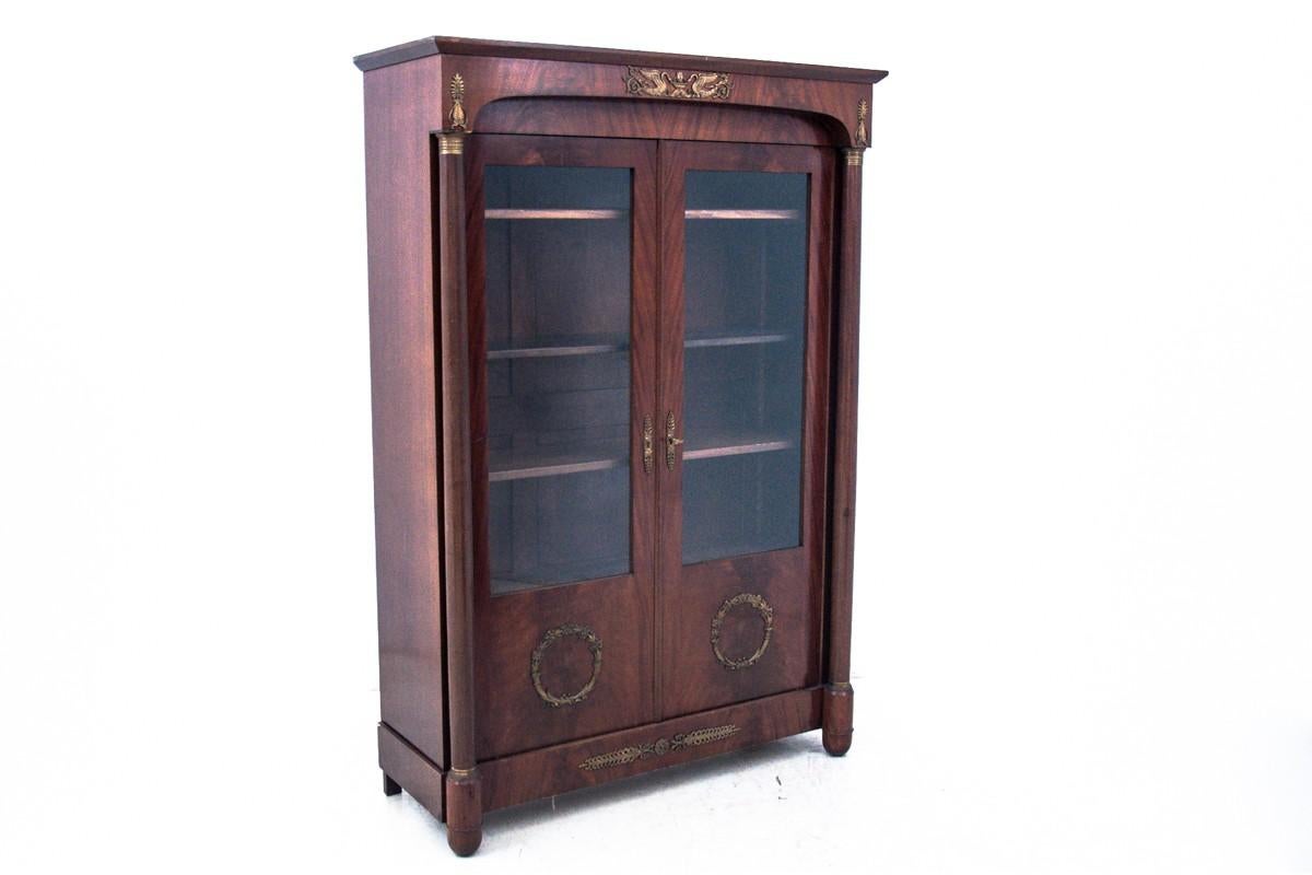 Library showcase, Empire, circa 1840. Antique.

The elegant Empire style piece of furniture comes from France. Made of mahogany wood, door leaves partially glazed in the middle, wooden shelves. Turned columns on the sides, the whole decorated with