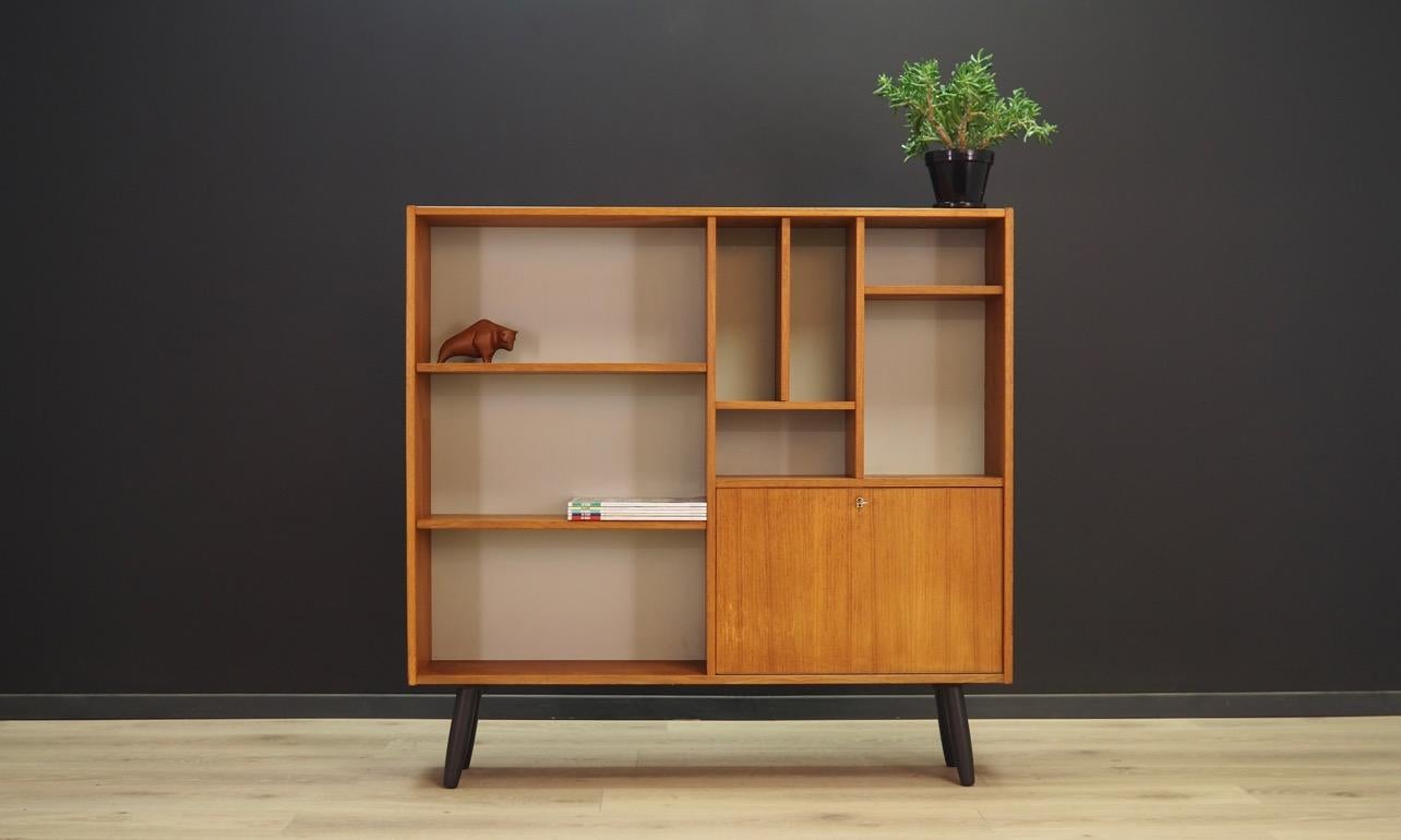 Unusual bookcase / library from the 1960s-1970s. Danish design - Minimalist form, high quality of workmanship and attention to detail. Surface finished with teak veneer. Bookcase has an original arrangement of shelves. Key in the set. Maintained in