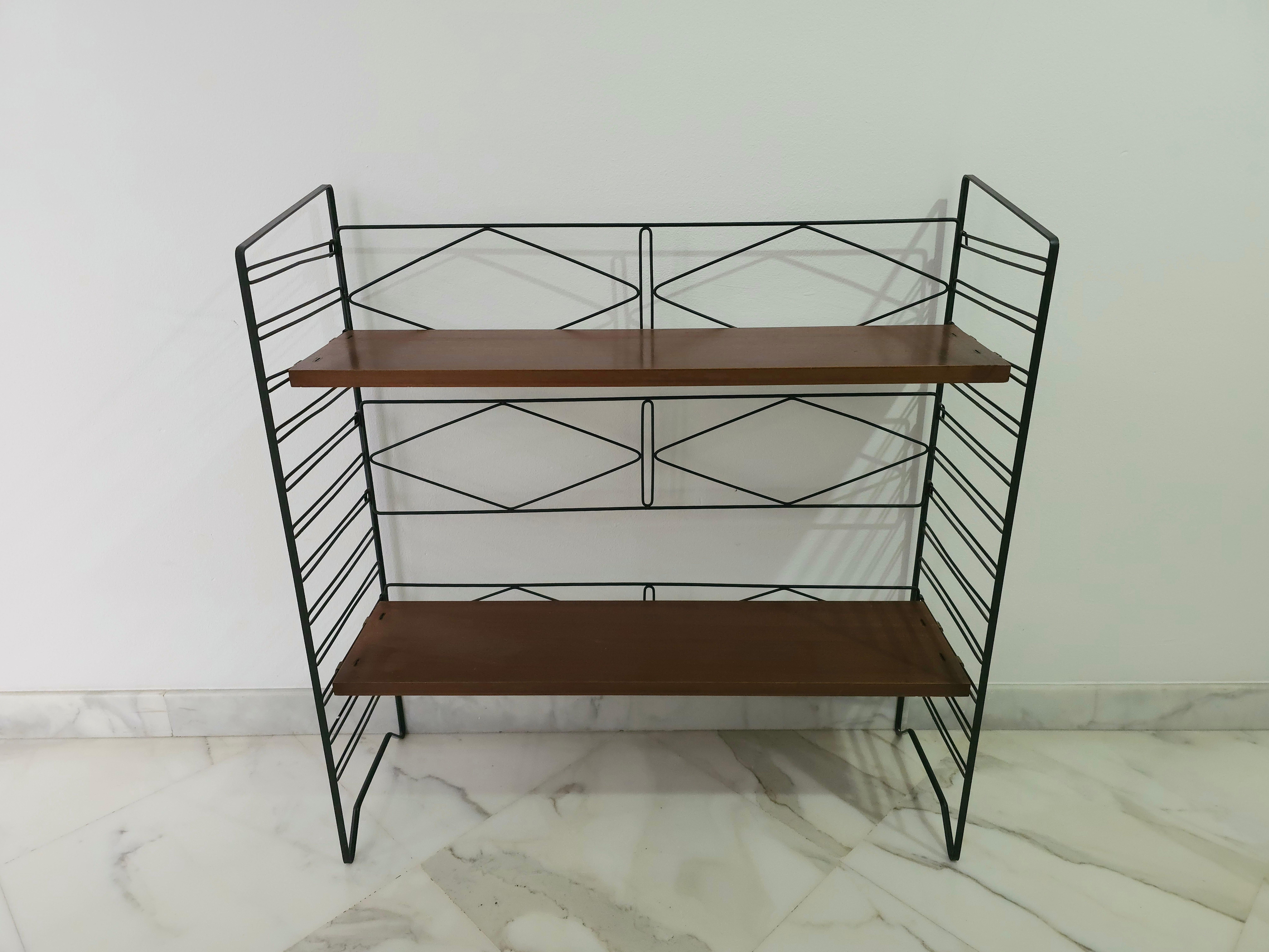 Small wall bookcase with a particular structure entirely in black enamelled metal with hooks that support 2 shelves in teak wood. Italian production of the 1960s. with a pleasant line

Shelf only measurements: 80x20x2 cm.

Note: We try to offer our