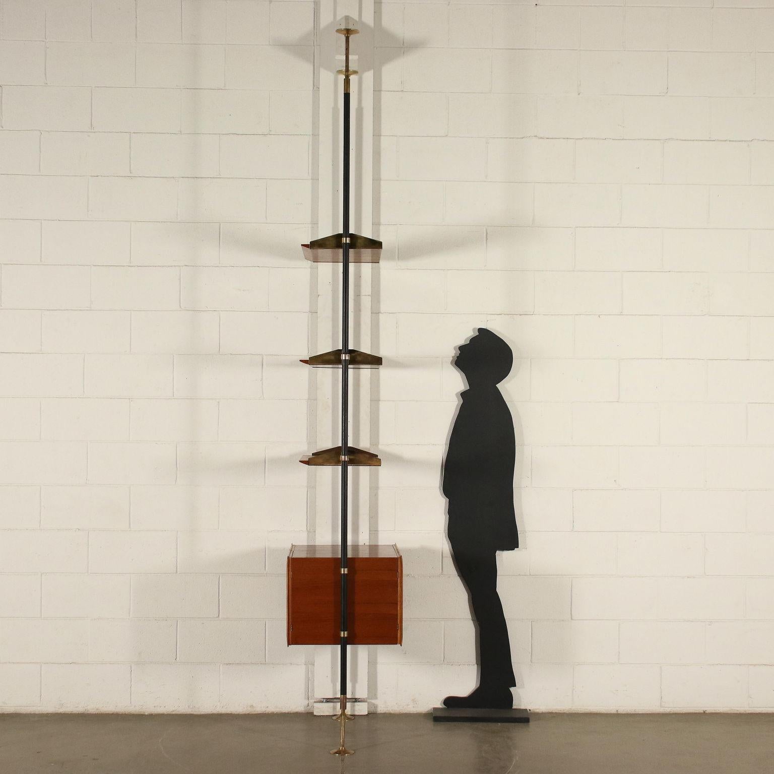 Floor to ceiling bookcase, that can be accessed from both sides with double opening of the compartment, adjustable shelves, teak veneer, enamelled metal uprights, brass supports and caps.